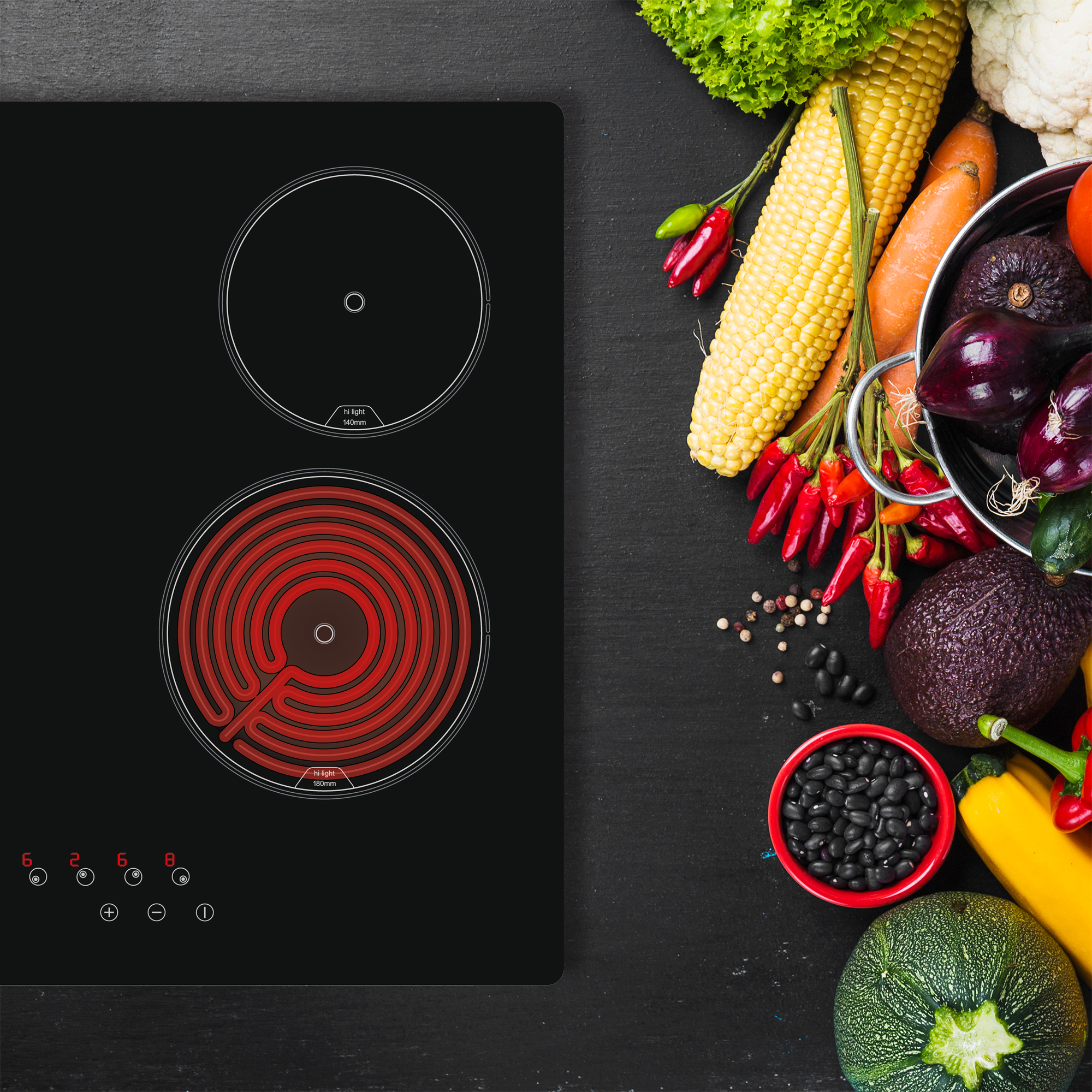 Encimera de inducción negra con dos quemadores. Verduras e ingredientes a la derecha.