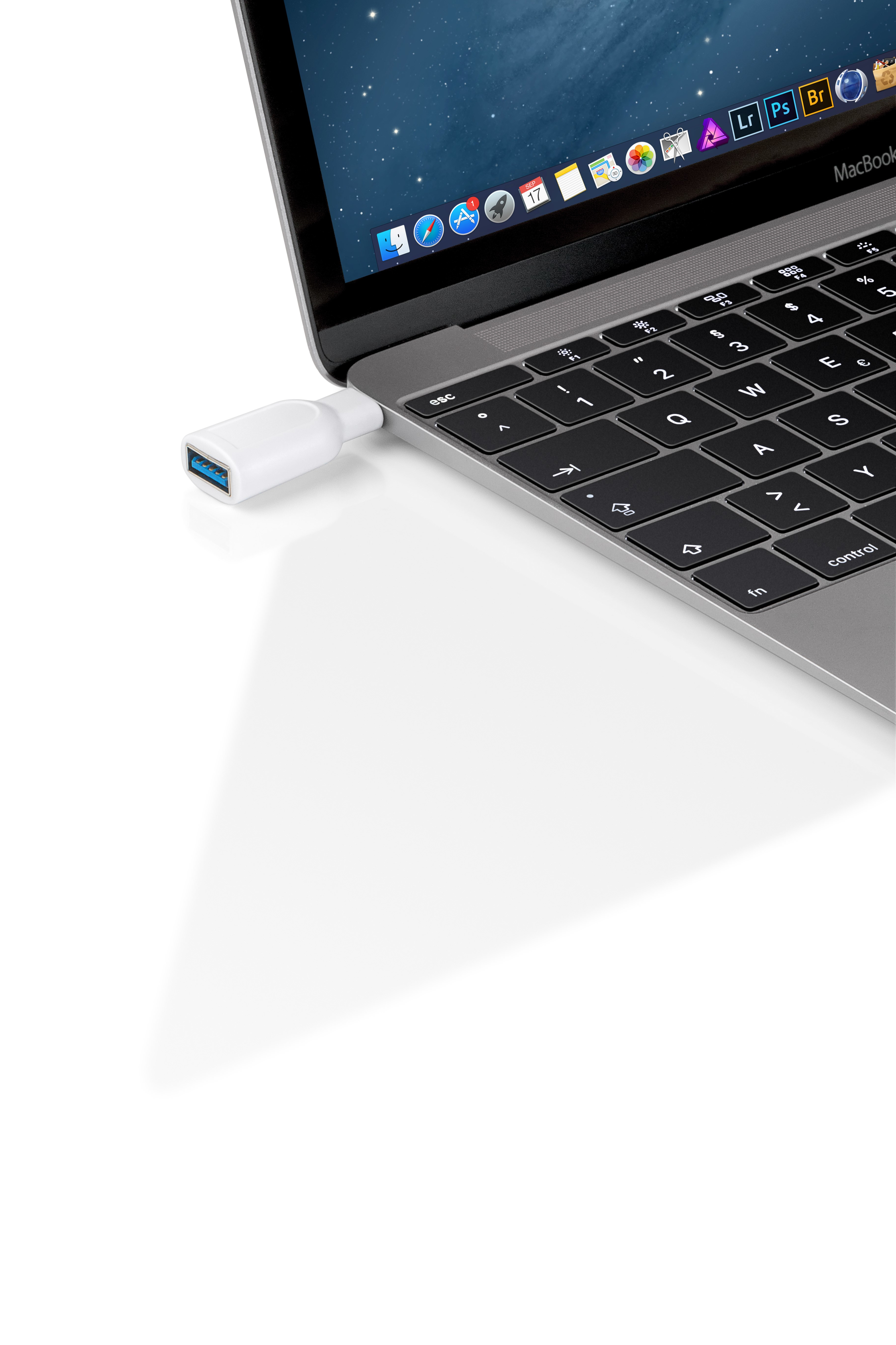 Biały adapter USB podłączony do MacBooka. Laptop jest otwarty.