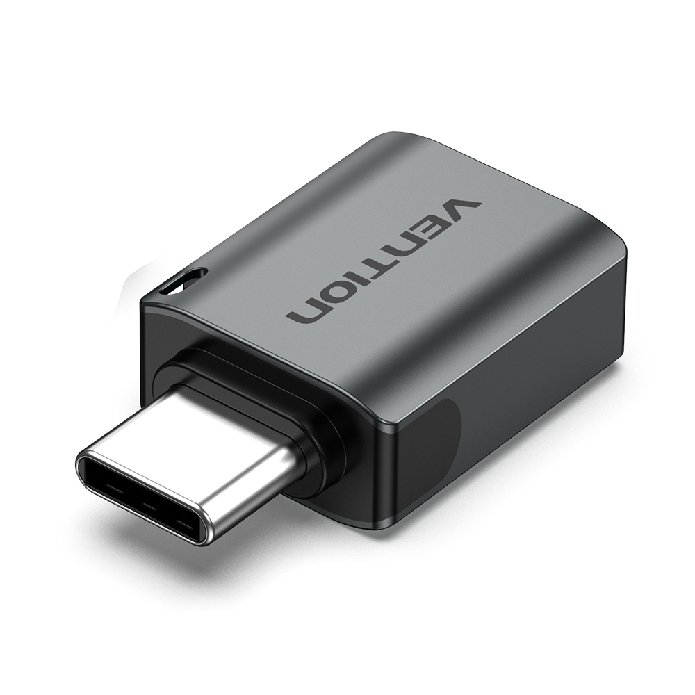 Un adattatore USB-C grigio con la parola "Vention" stampata. Su sfondo bianco.