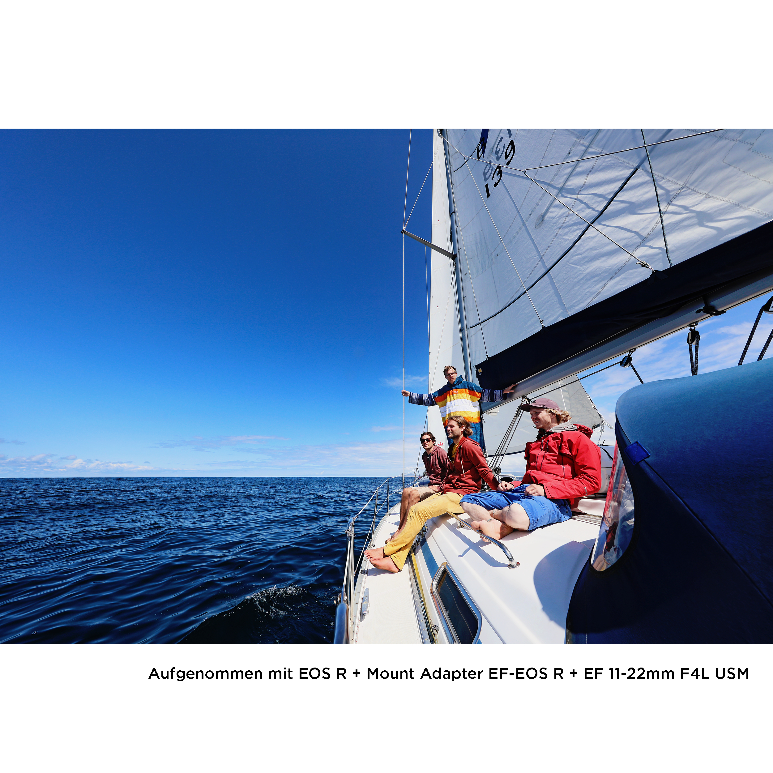 Segelboot mit Menschen an einem sonnigen Tag, Ozean und blauer Himmel im Hintergrund.