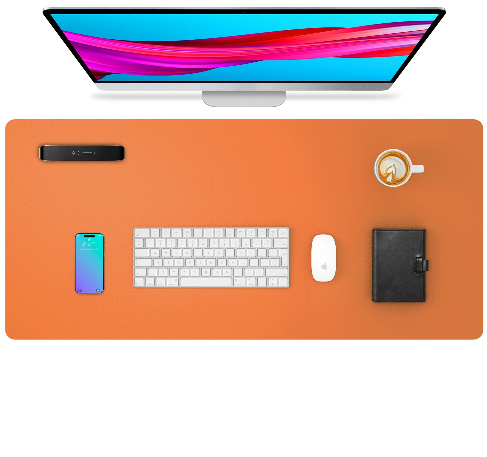 Orangefarbene Schreibtischunterlage mit Monitor, Telefon, Tastatur, Maus und Notizbuch.