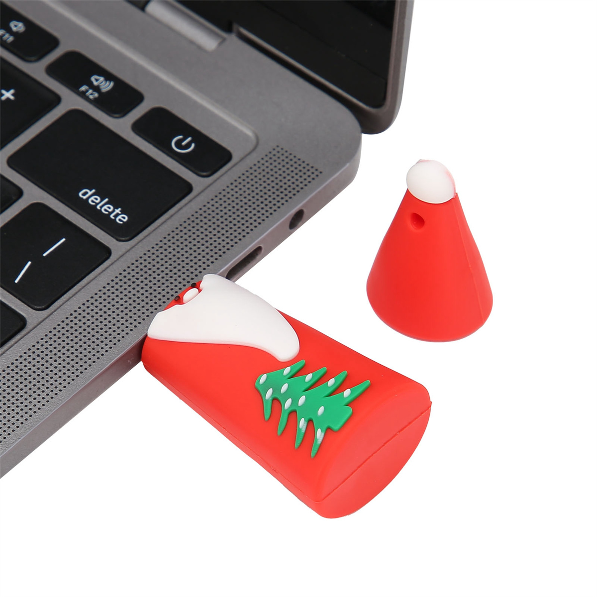 USB-Stick mit Weihnachtsbaum-Design, neben einem roten Weihnachtsmannhut.
