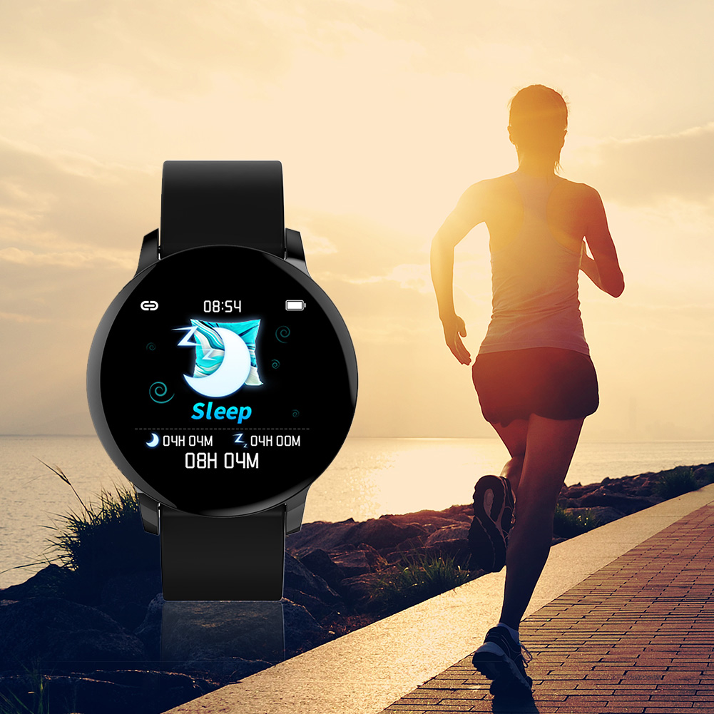 Eine schwarze Smartwatch mit einer Läufer-Silhouette vor einem Sonnenaufgang über dem Wasser.