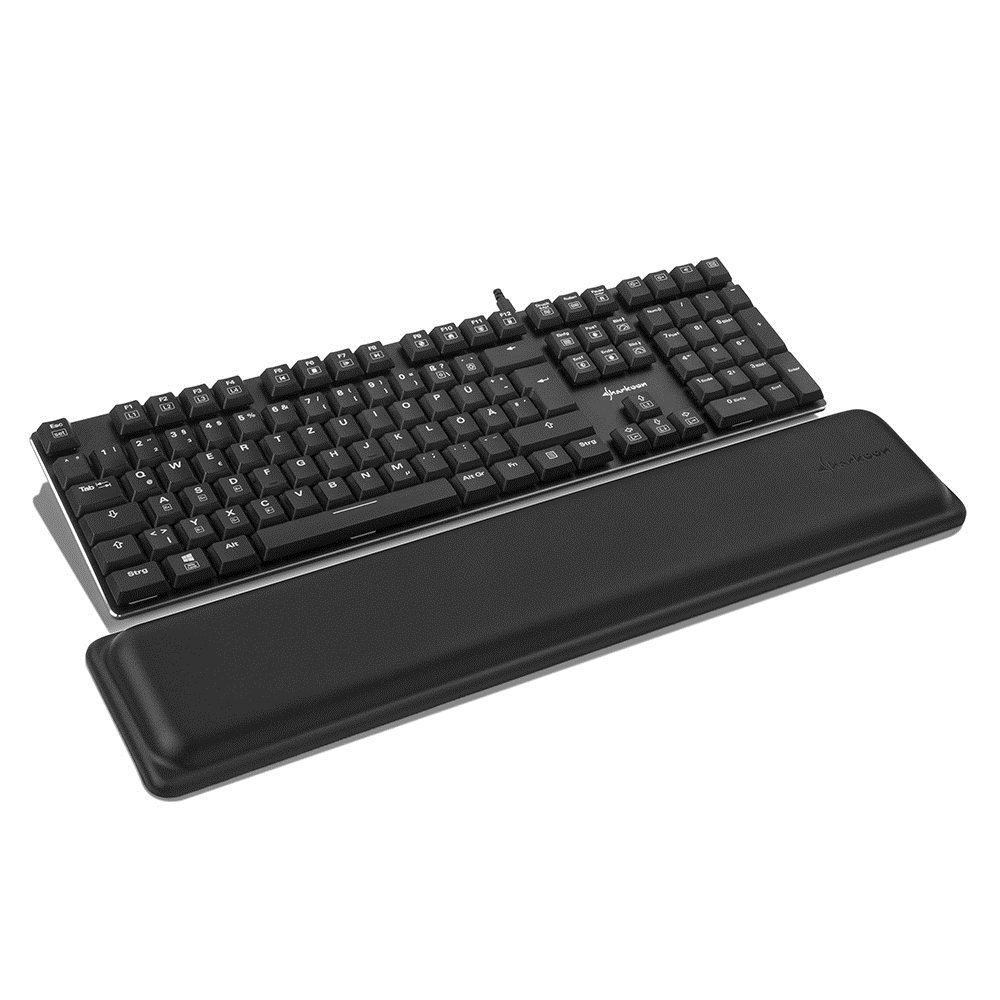 Teclado negro con teclas blancas y reposamuñecas negro sobre superficie blanca.