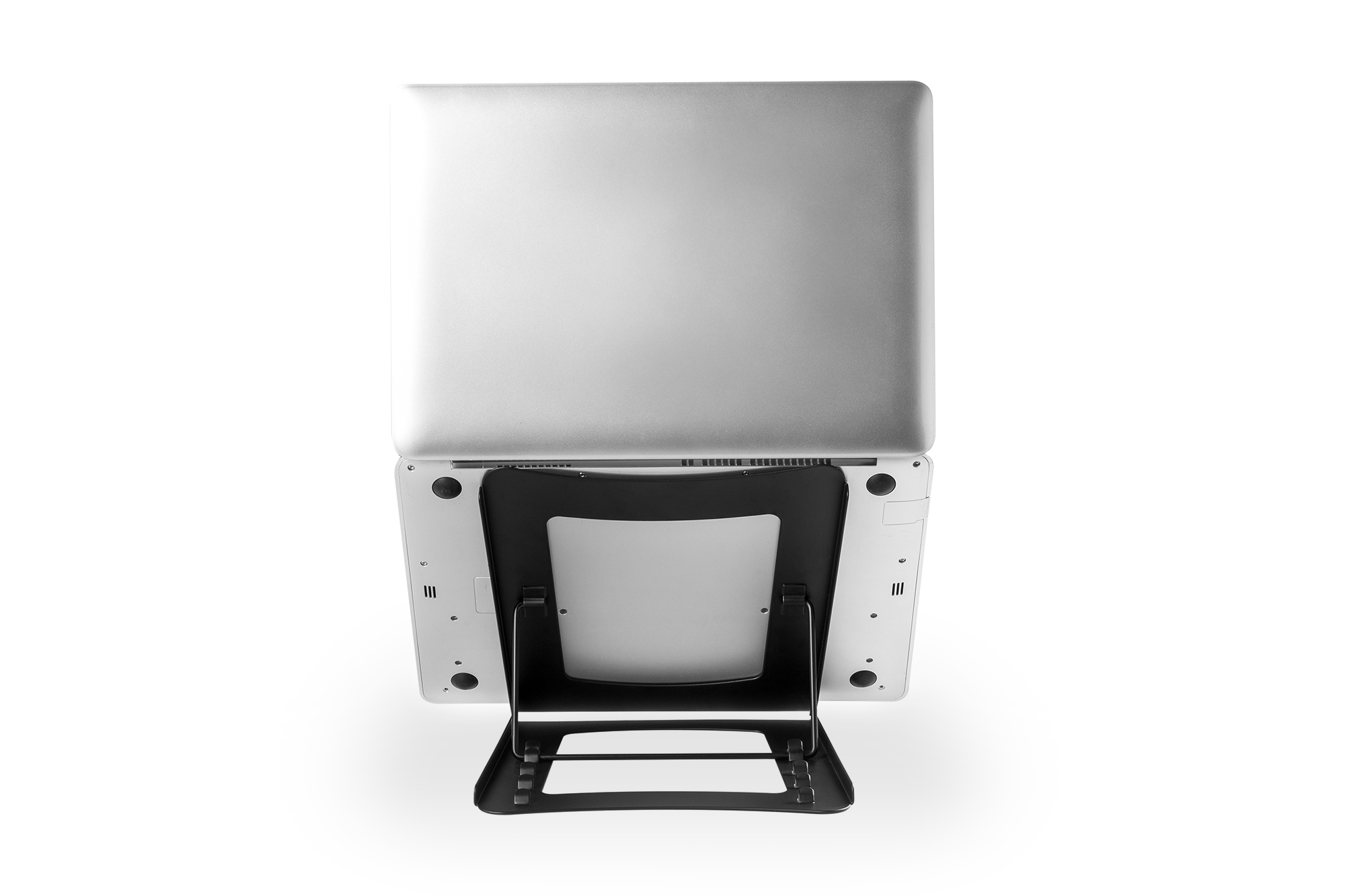 Laptop na czarnym stojaku. Laptop jest srebrny, a stojak czarny z siatkową podstawą.