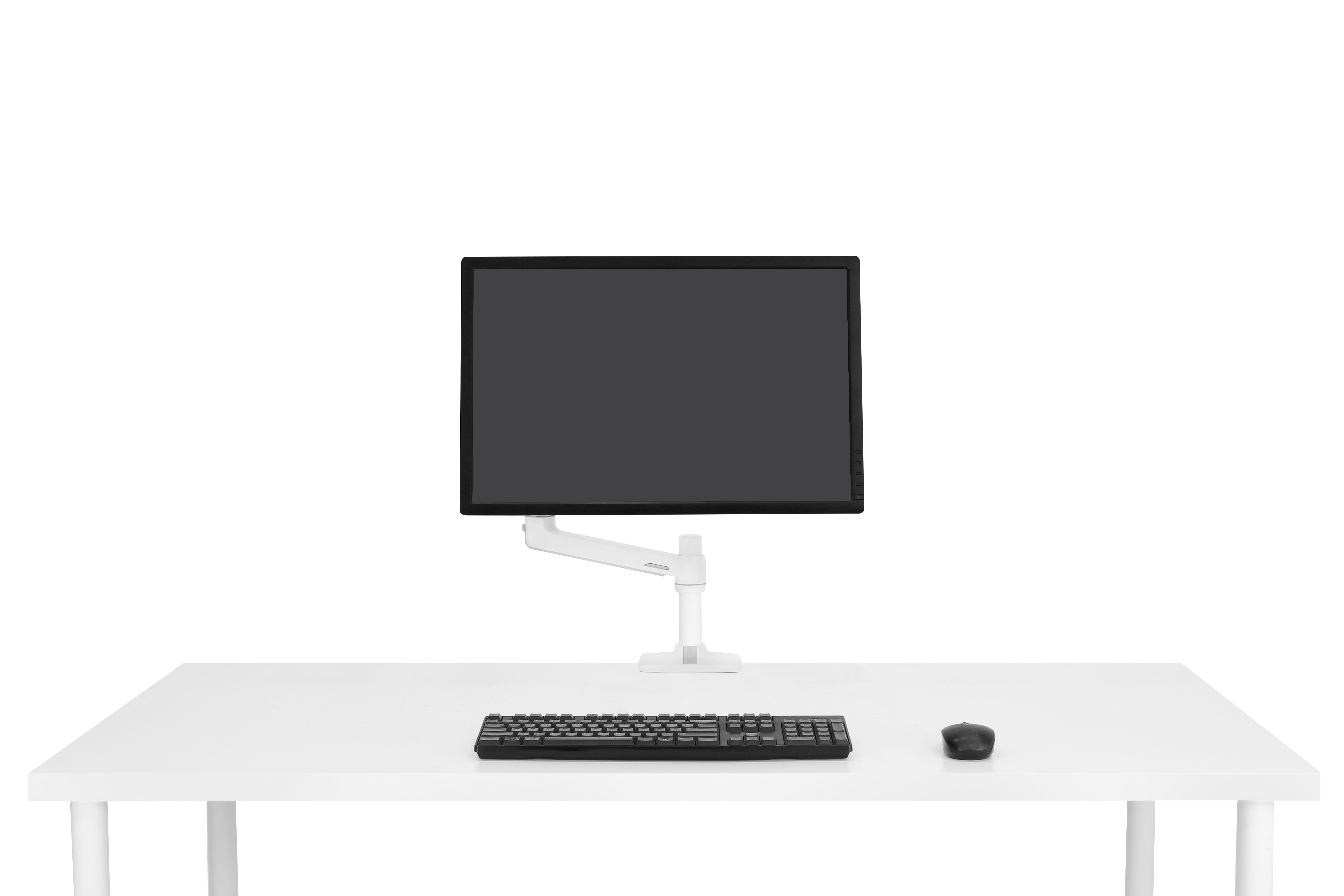 A white desk with a monitor on an arm, keyboard, and mouse.