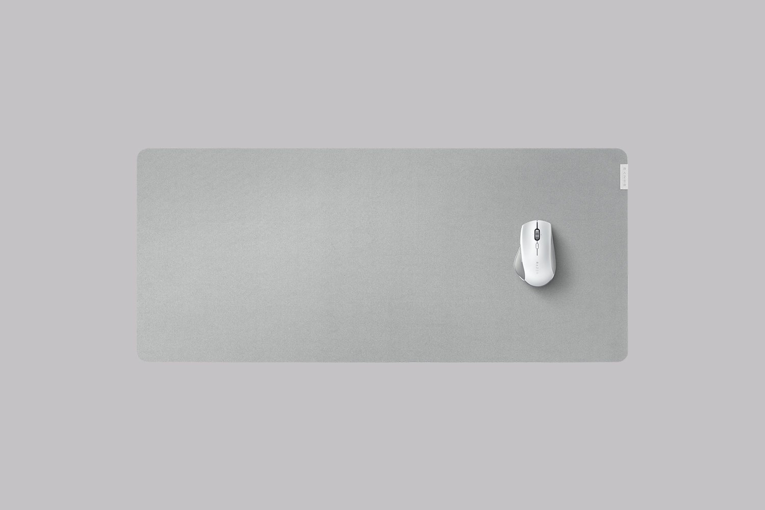 Szara podkładka pod mysz z białą myszą, na szarym tle, widok z góry.