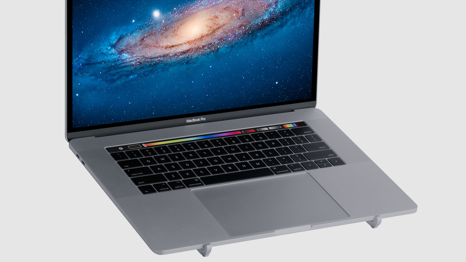 Laptop mit einem Galaxie-Themenbildschirm, der auf einem silbernen Ständer ruht.