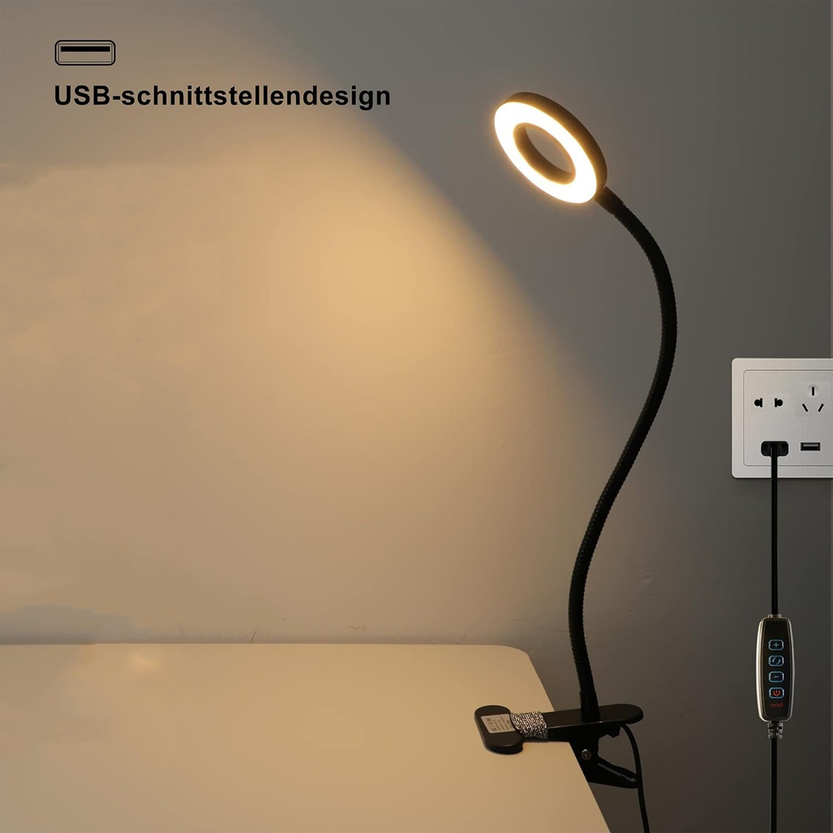 Schwarze Schreibtischlampe mit Ringlicht und Clip, eingesteckt in eine Steckdose.