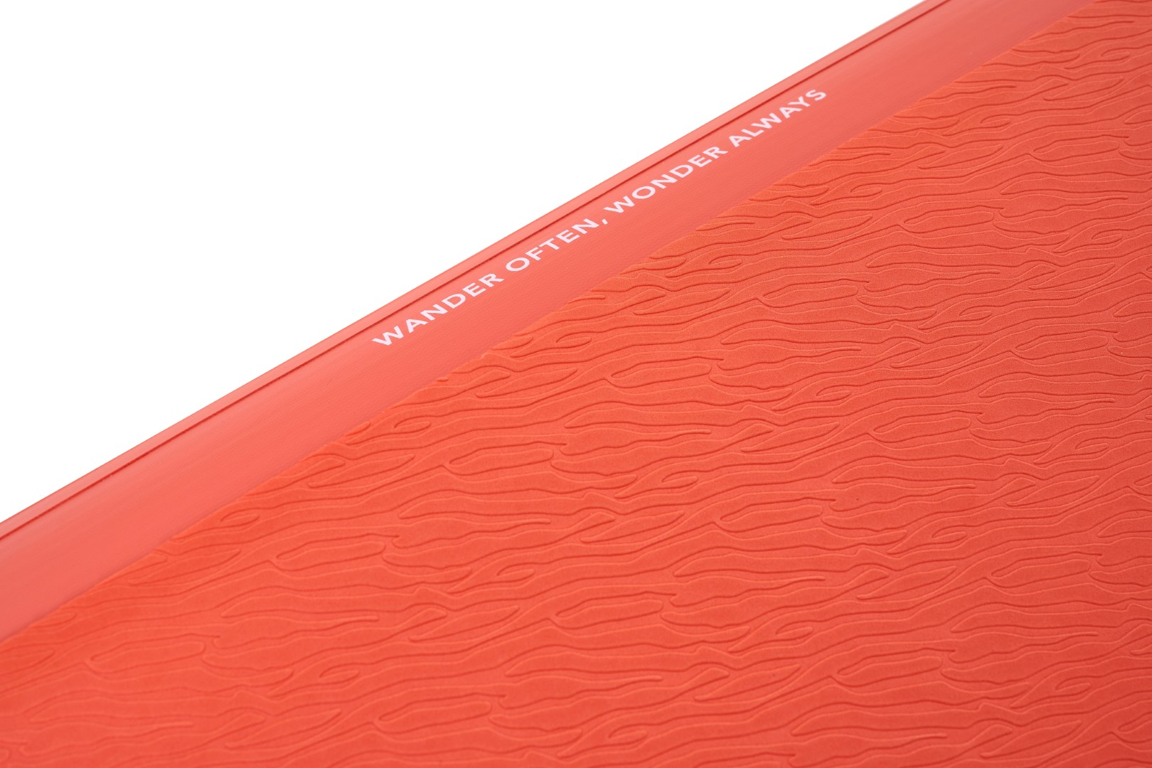 Czerwona, teksturowana powierzchnia ze słowami 'WANDER OFTEN, WONDER ALWAYS' w białym tekście.