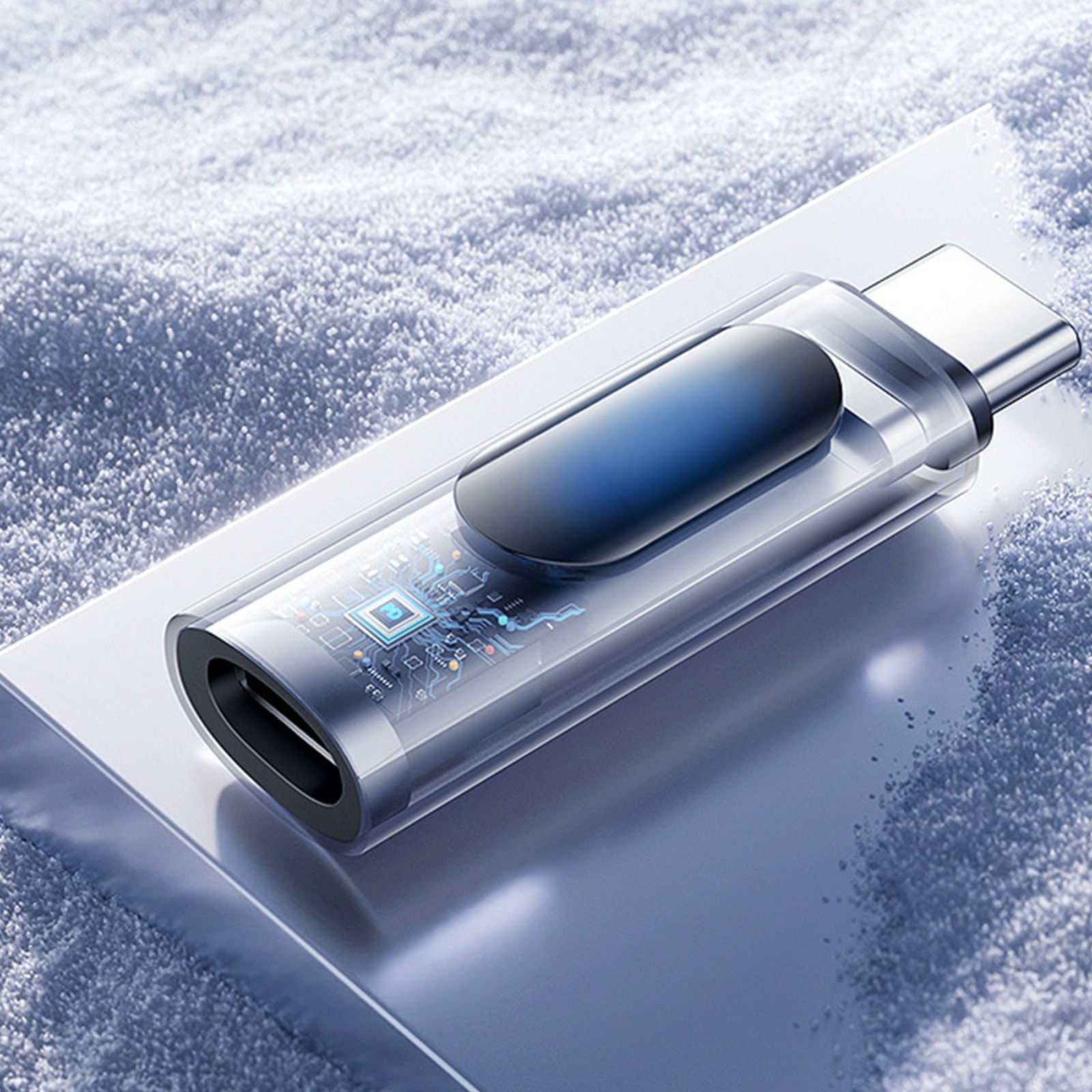 Ein durchsichtiger USB-C-Adapter mit blauem Innenleben auf weißer, schneebedeckter Oberfläche.