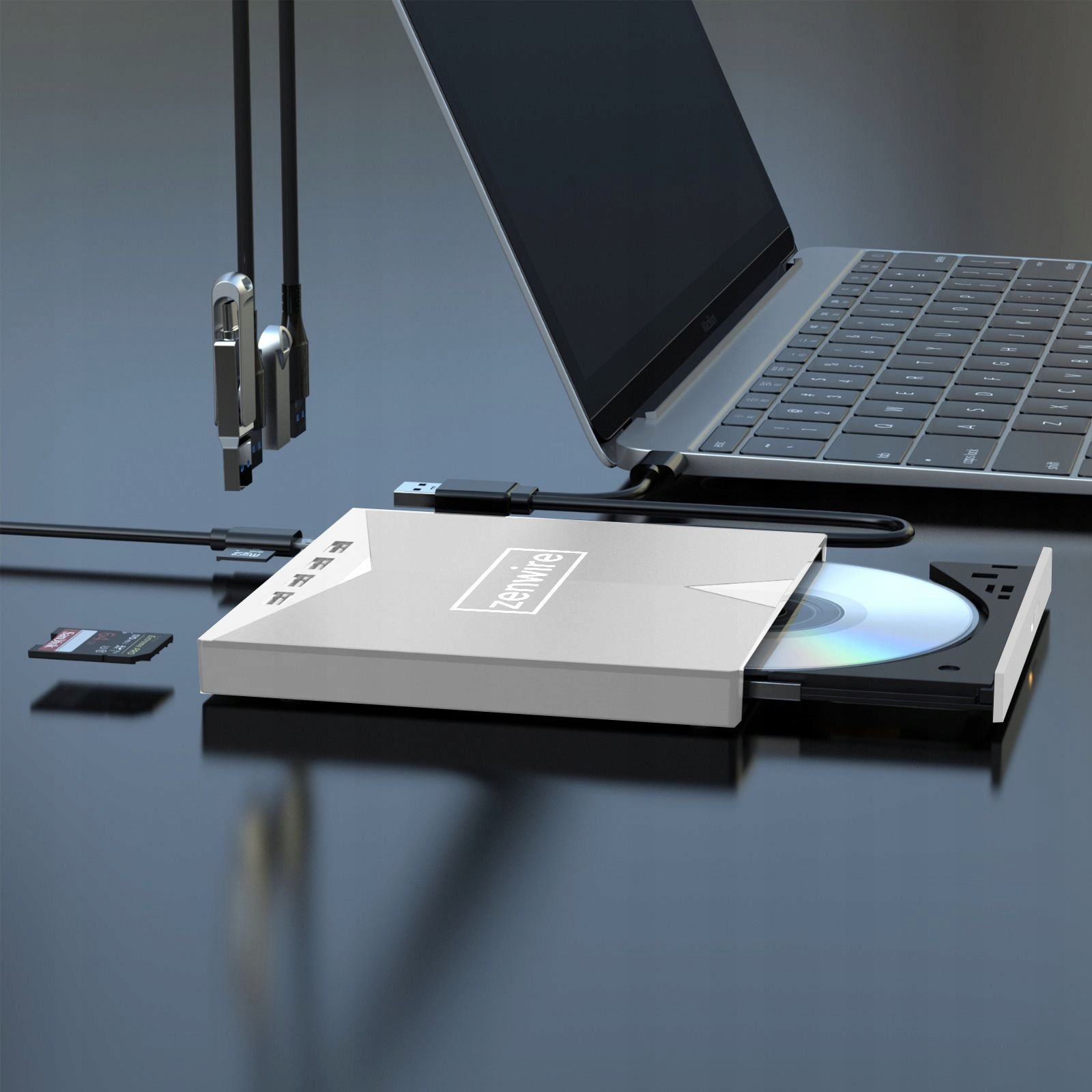 Laptop z zewnętrznym napędem DVD, kartą SD i kablami USB.