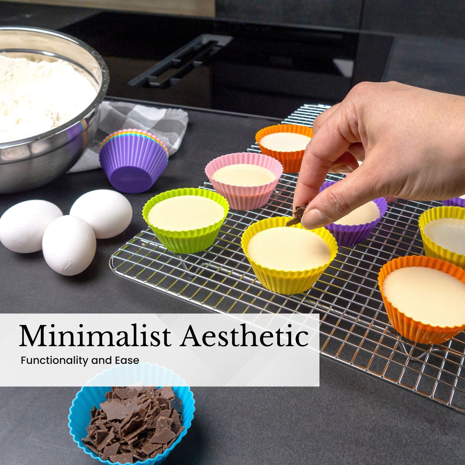 Eine Person legt Schokostückchen auf Cupcakes. Zutaten: Eier, Mehl und Cupcake-Förmchen. Die Szene ist auf schwarzem Untergrund.