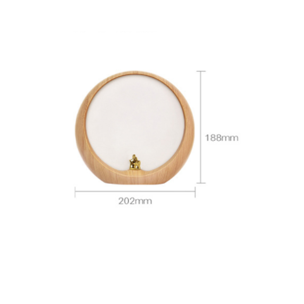 Eine runde Holzlampe mit weiß beleuchtetem Zentrum und einer kleinen goldenen Figur darin.