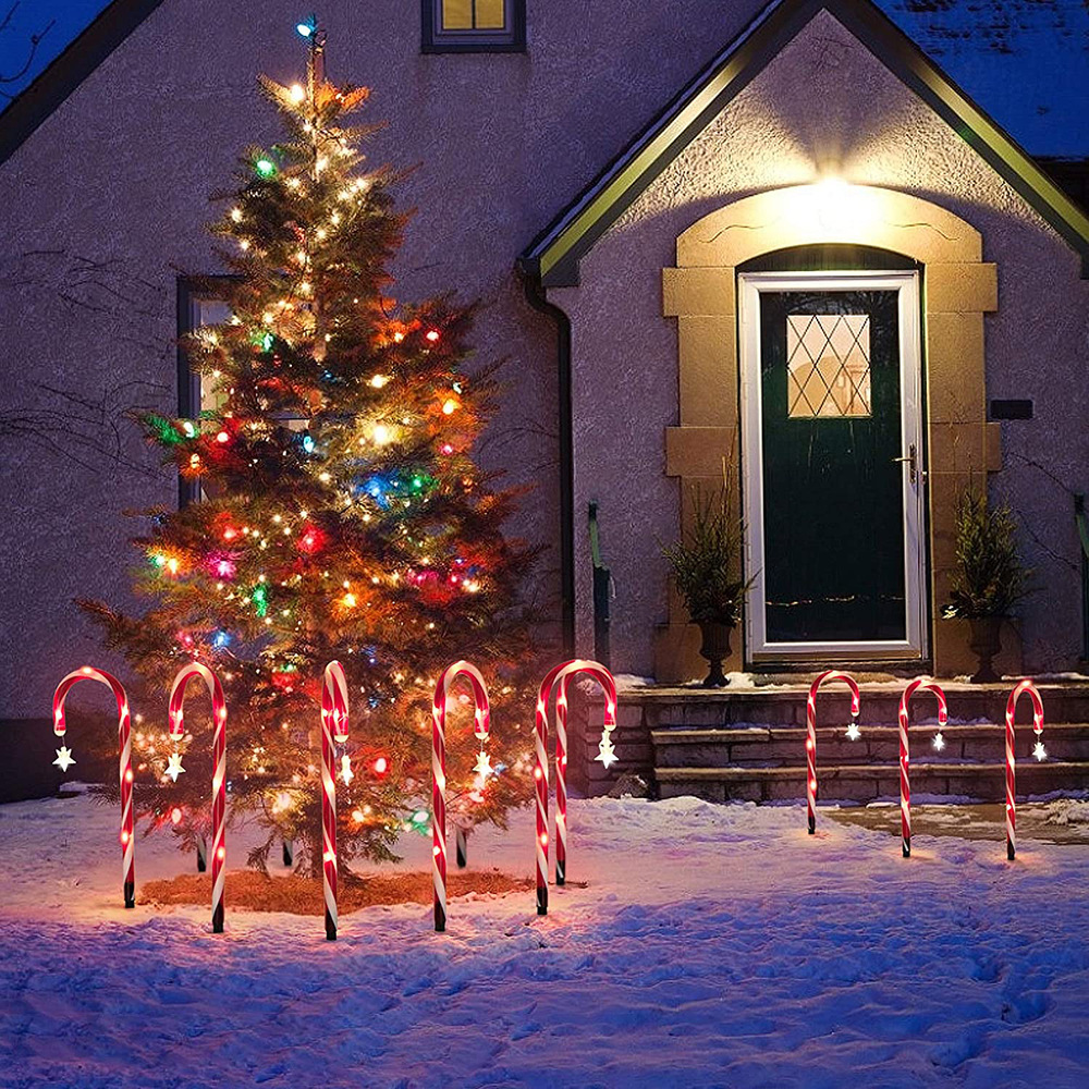 Weihnachtsszene mit beleuchtetem Baum, Zuckerstangen und Schnee.