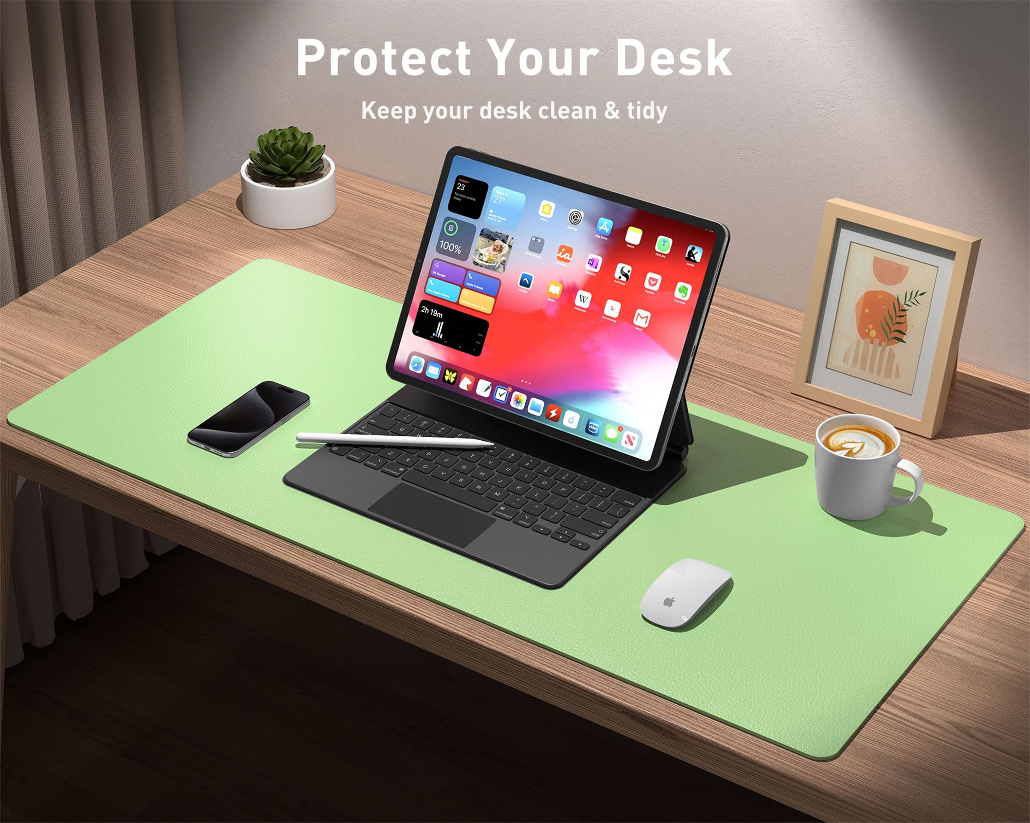 Grüne Schreibtischunterlage mit Laptop, Telefon und Kaffeetasse auf einem Holztisch. Weißer Hintergrund.