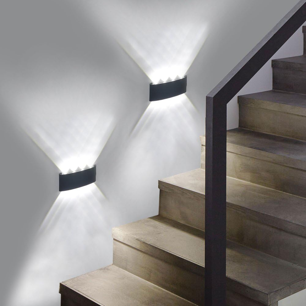 Zwei schwarze Wandlampen an einer weißen Wand. Die Lampen befinden sich auf einer Treppe.