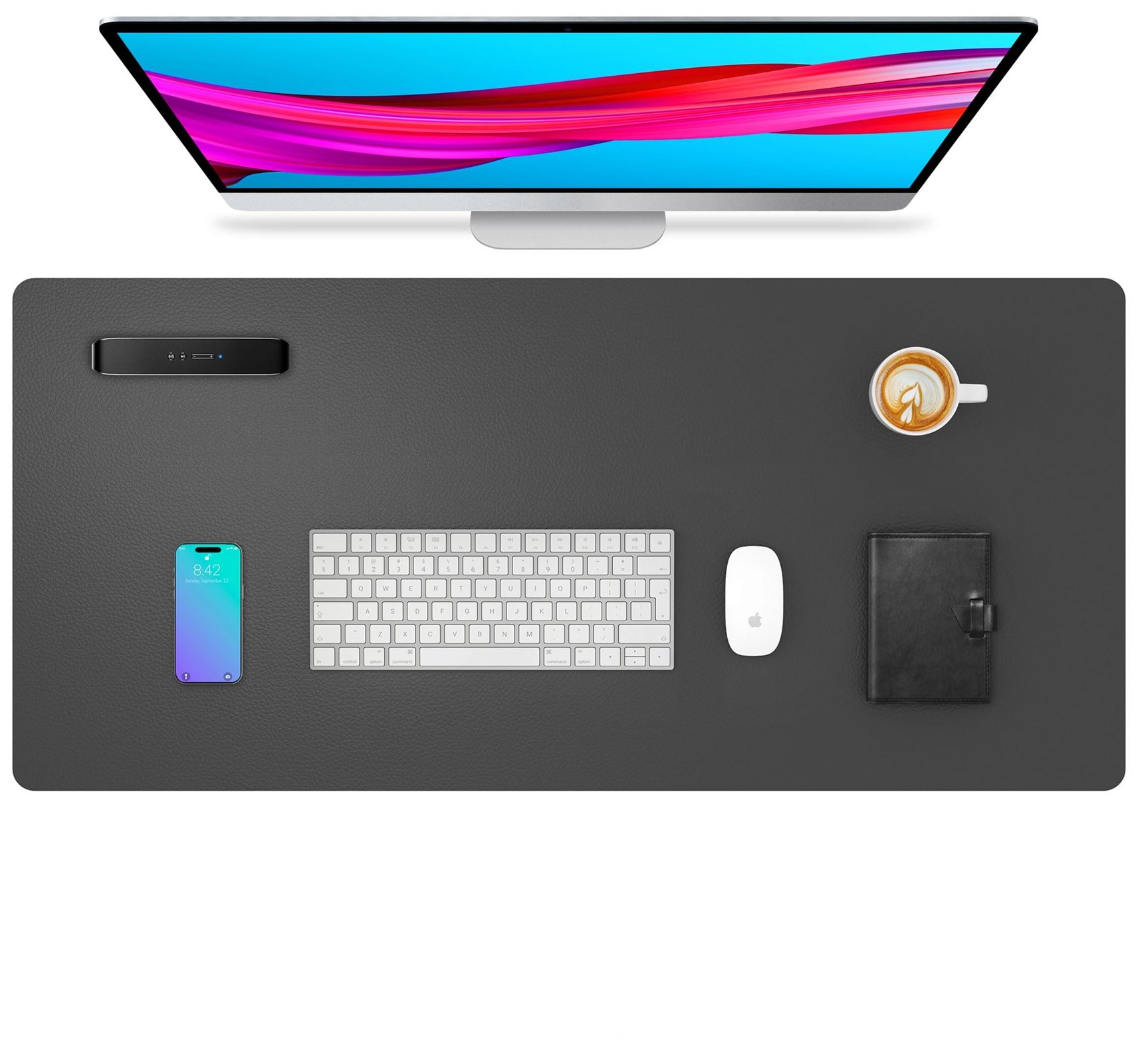 Ein Schreibtisch-Setup mit Monitor, Tastatur, Maus, Telefon, Notizbuch und Kaffeetasse.