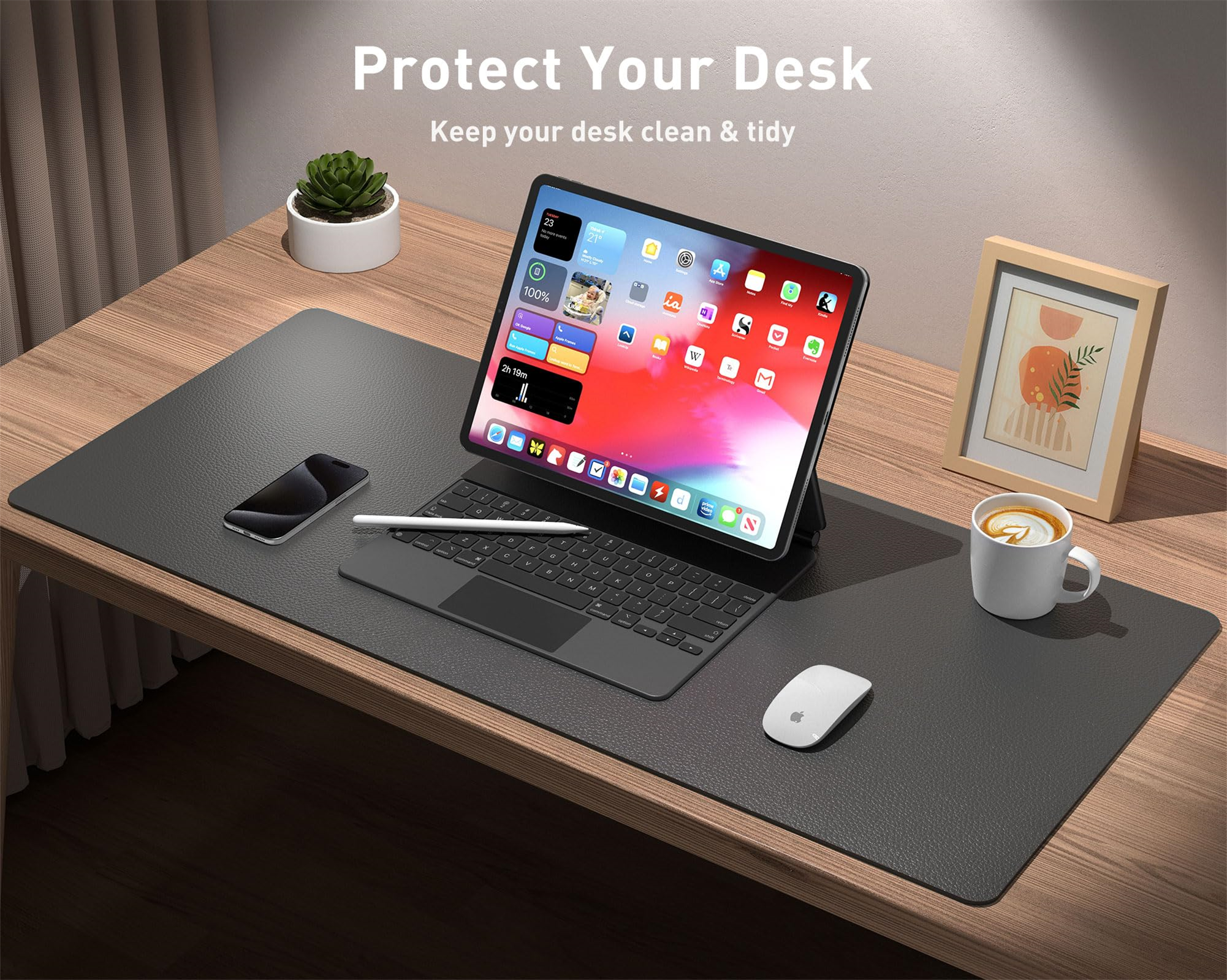 Ein Schreibtisch mit einem Tablet, einer Tastatur, einer Maus, einer Tasse und einem Stift. Es gibt eine Schreibtischunterlage.