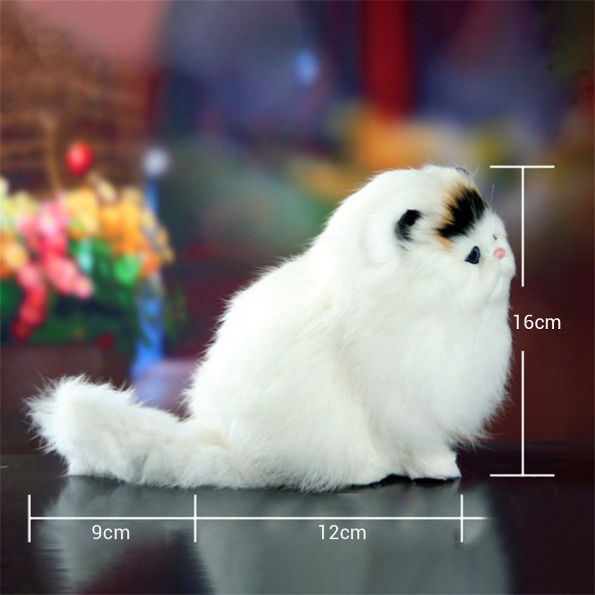 Flauschiges weißes Katzenplüschtier mit schwarzen Markierungen. Abmessungen: 12 cm lang, 16 cm hoch.