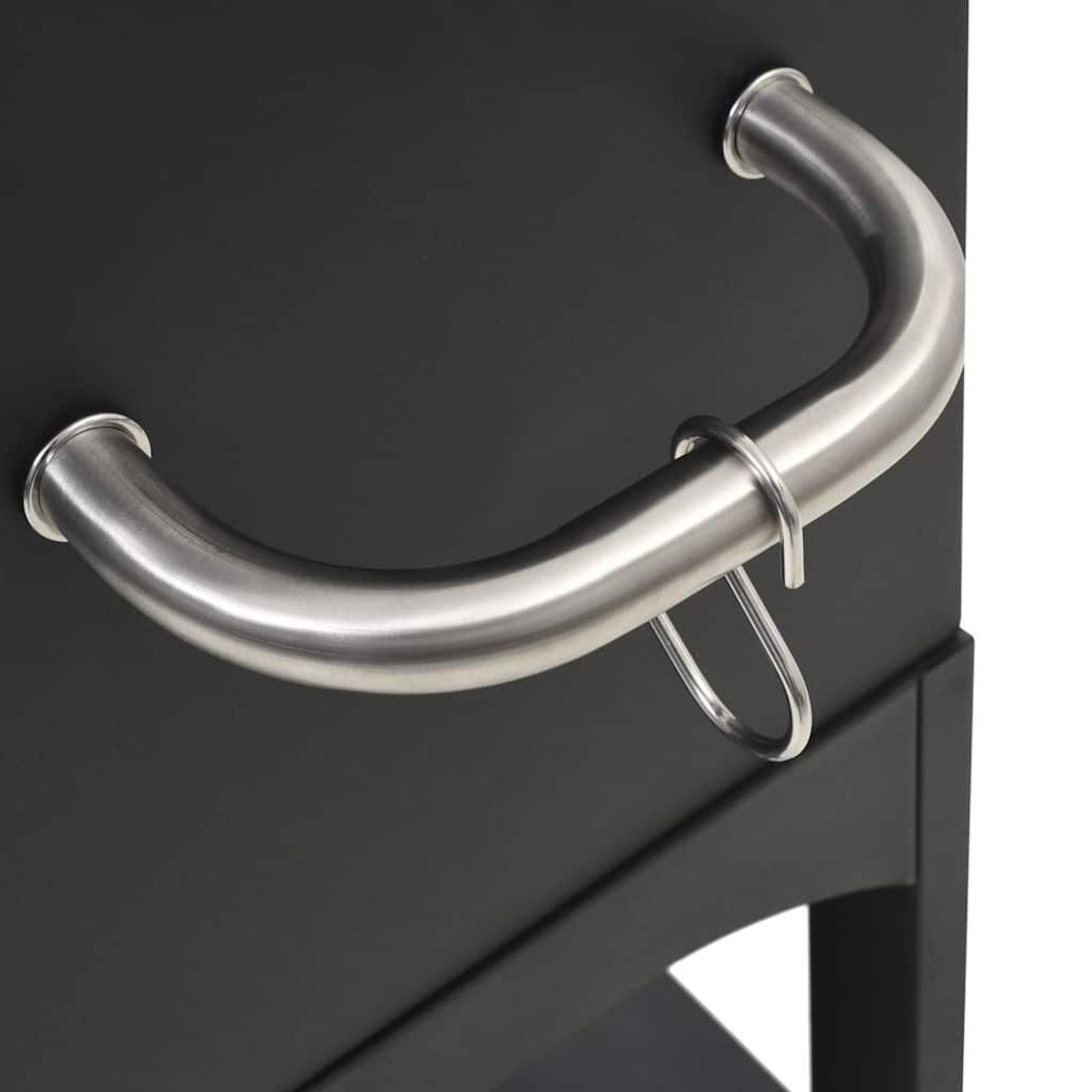 Nahaufnahme eines schwarzen Metallgriffs auf schwarzer Oberfläche, mit einem silbernen Ring.