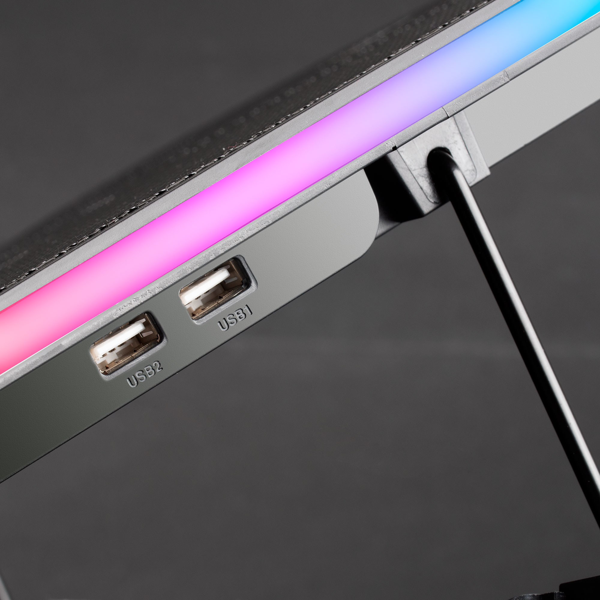 Primer plano de un enfriador de portátil con puertos USB y luces RGB.