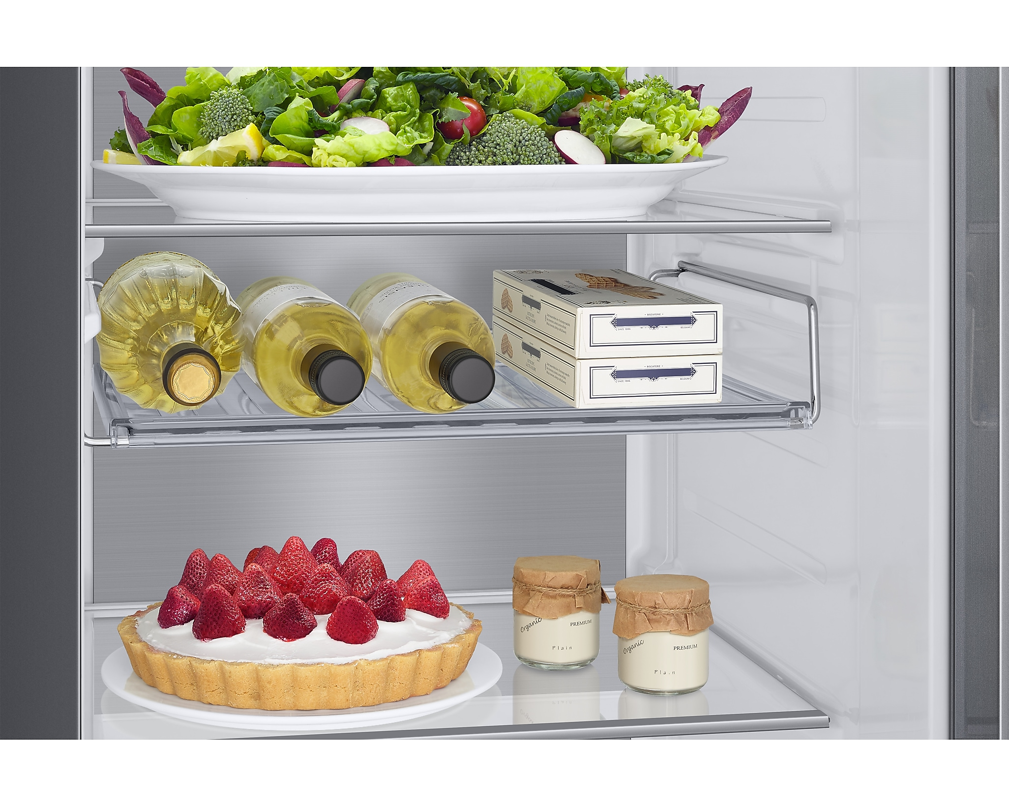 All'interno di un frigorifero con cibo, tra cui bottiglie di vino e una crostata di fragole.