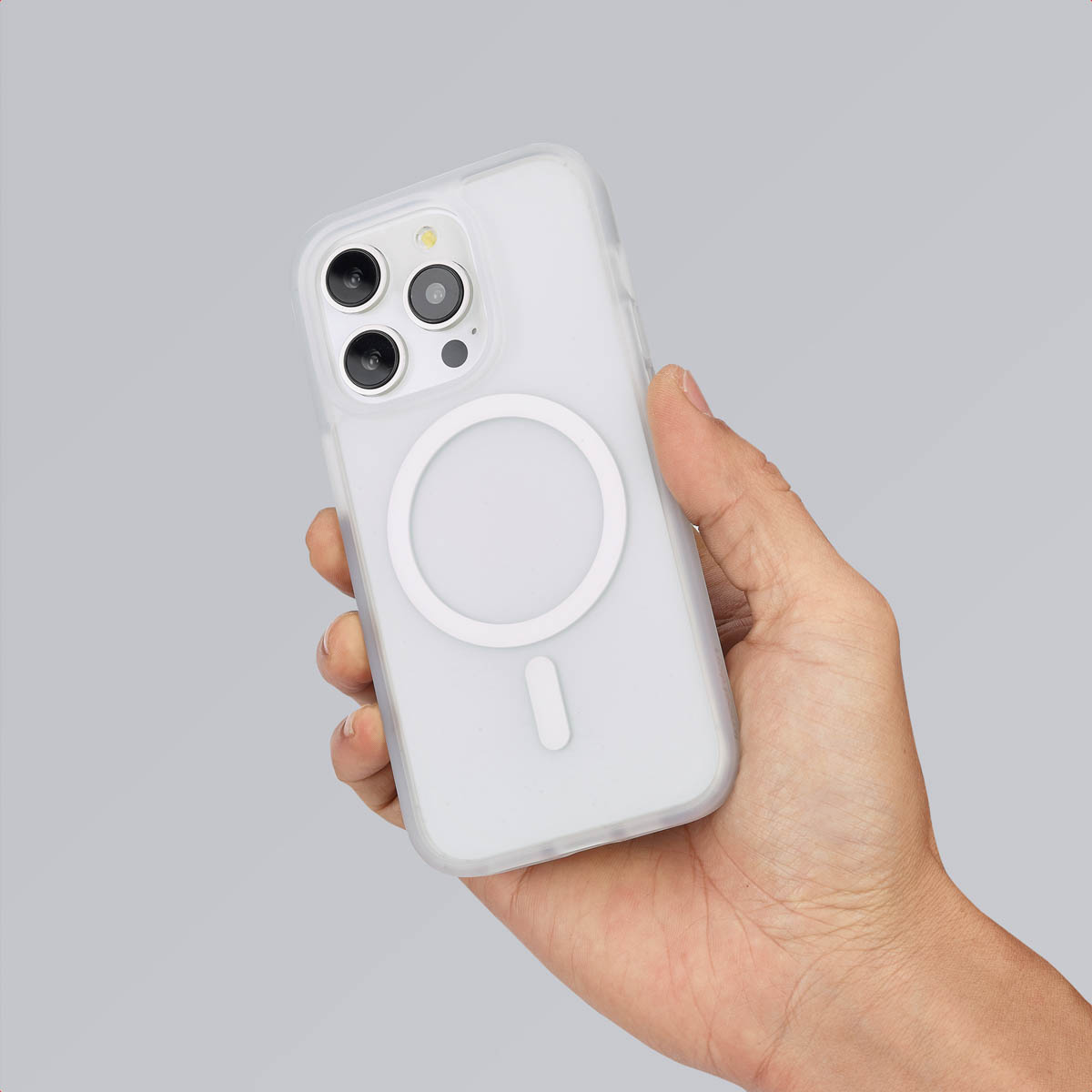 Een hand die een telefoon vasthoudt met een witte hoes. De hoes heeft een witte cirkel op de achterkant.