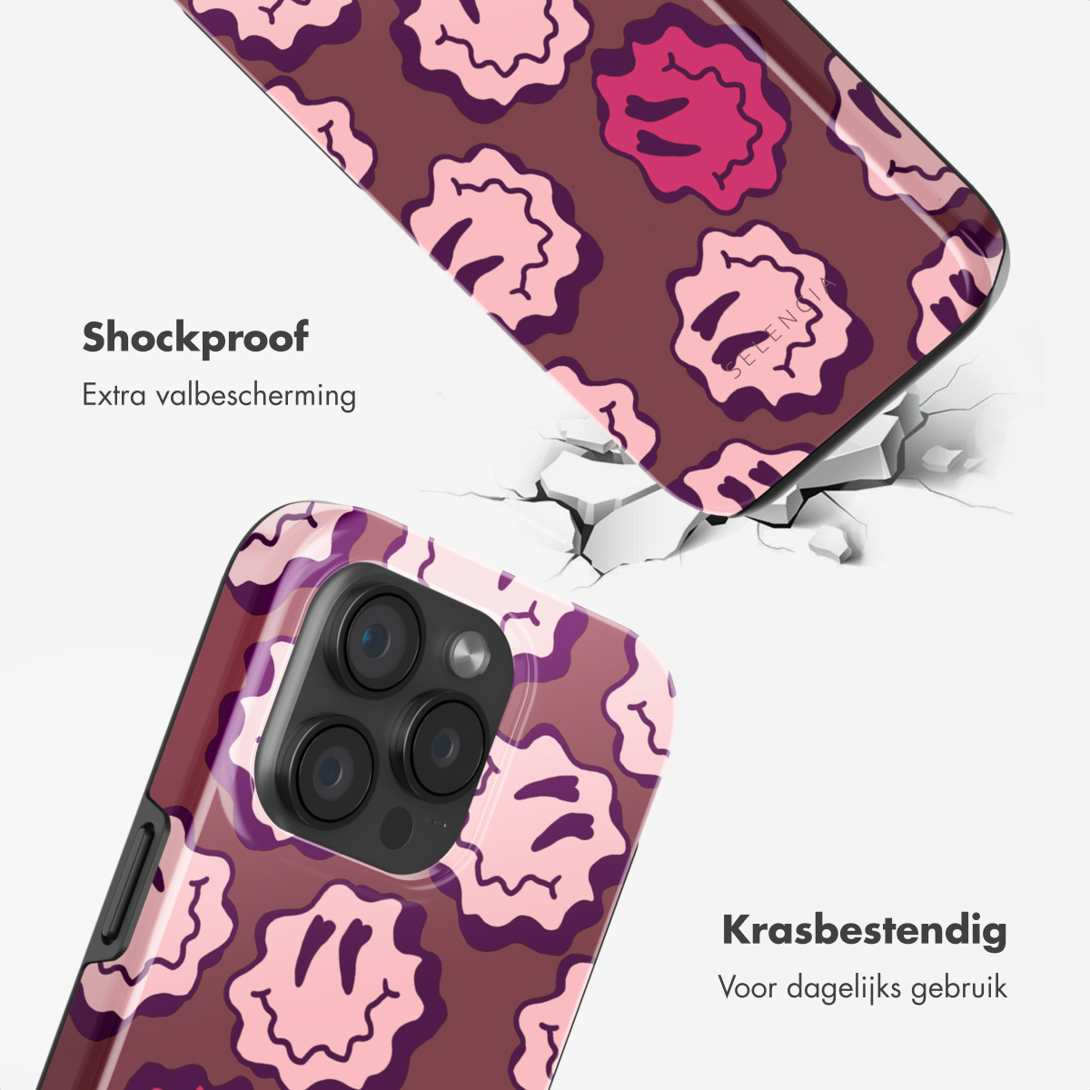 Coque de téléphone, motif de visages souriants roses. Surface fissurée, détail du téléphone. Texte : Antichoc, Extra valbescherming et Krasbestendig.