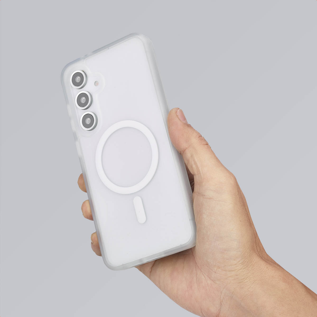 Hand houdt een telefoon vast met een witte hoes. De achterkant heeft een heldere cirkel.