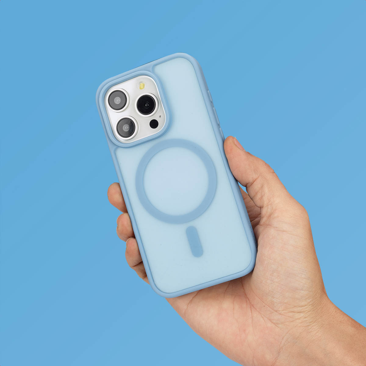 Een hand houdt een blauwe telefoonhoes vast. De hoes heeft een cirkel en een rechthoek op de achterkant.