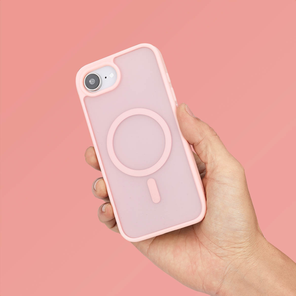 De hand van een persoon die een roze telefoonhoes en een roze telefoon vasthoudt.