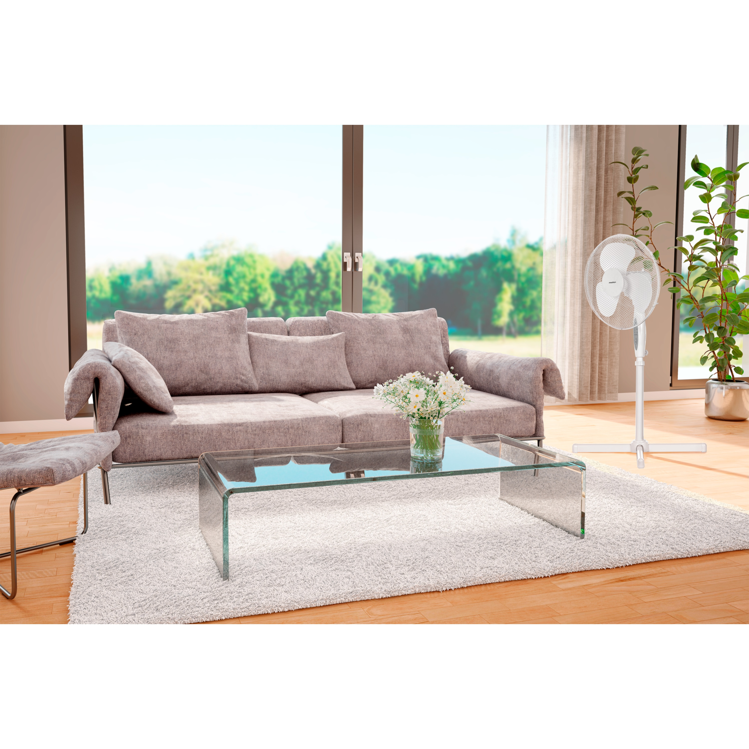 Salon z sofą, stolikiem kawowym, wentylatorem, kwiatami i dużym oknem.