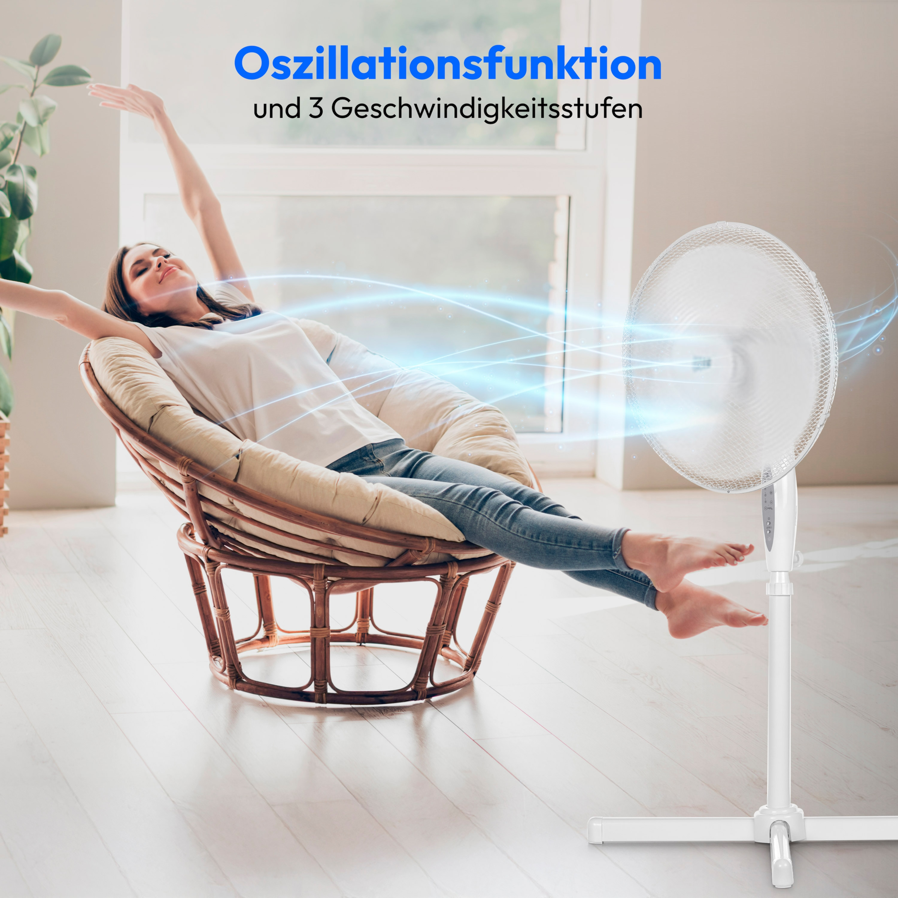 Kobieta relaksująca się z wyciągniętymi ramionami przed białym wentylatorem.