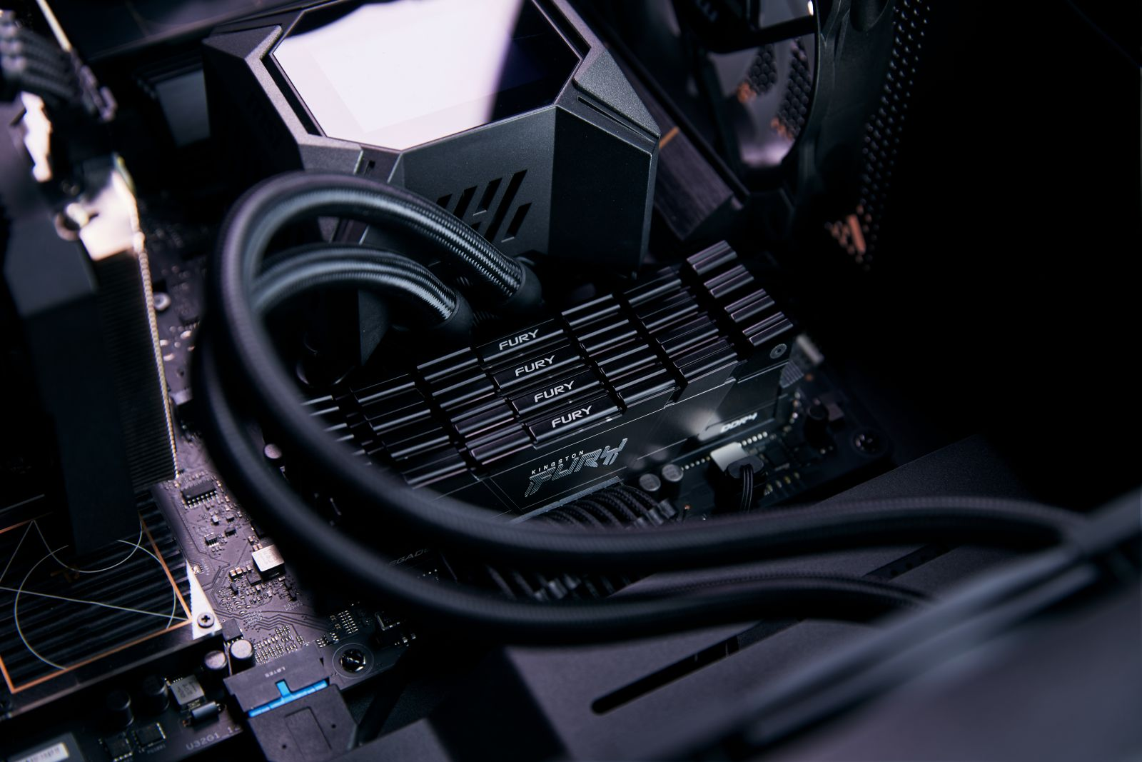 Zbliżenie na wewnętrzne komponenty komputera, w tym moduł RAM oznaczony 'FURY'.