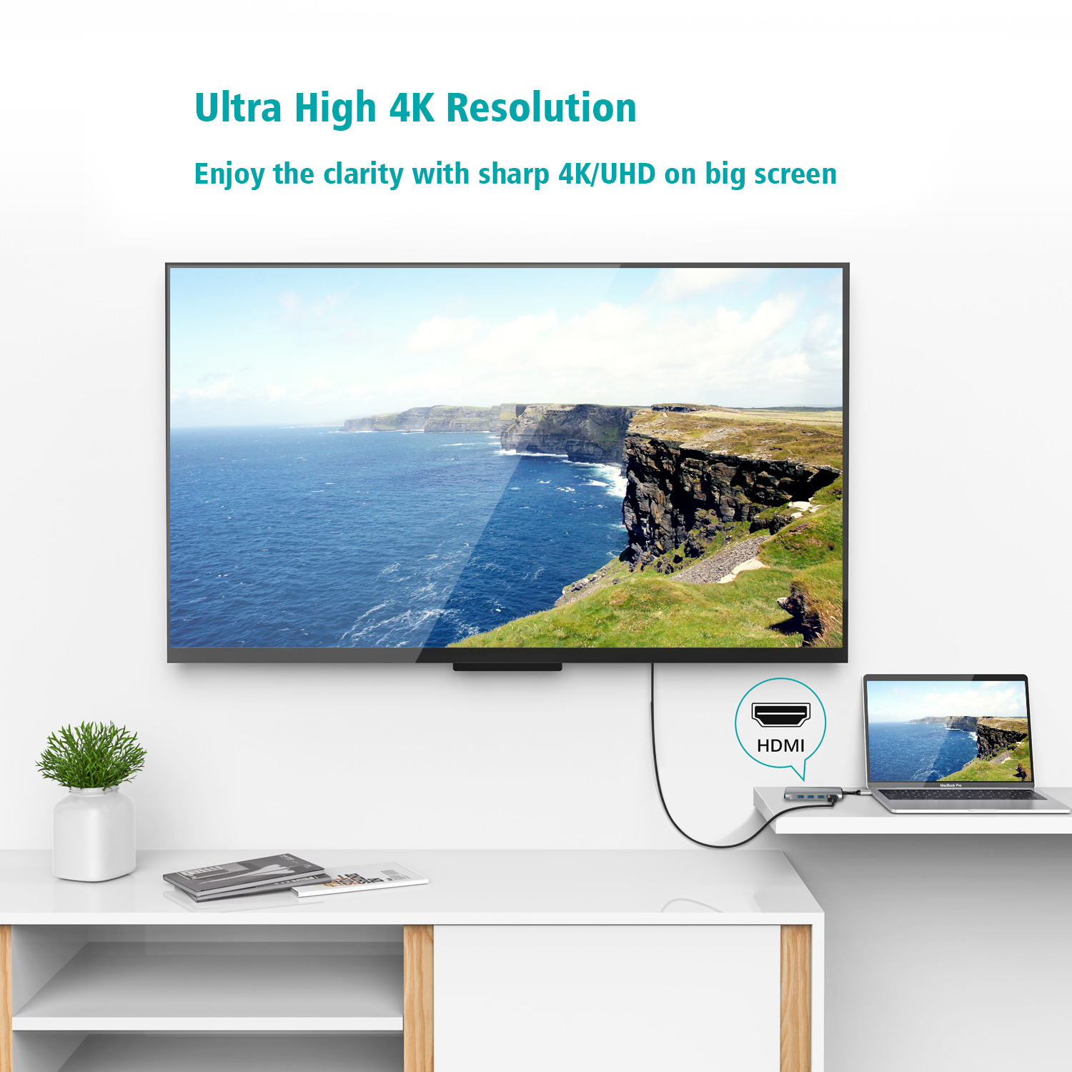 Een tv met een kustlandschap is via een HDMI-kabel verbonden met een laptop.