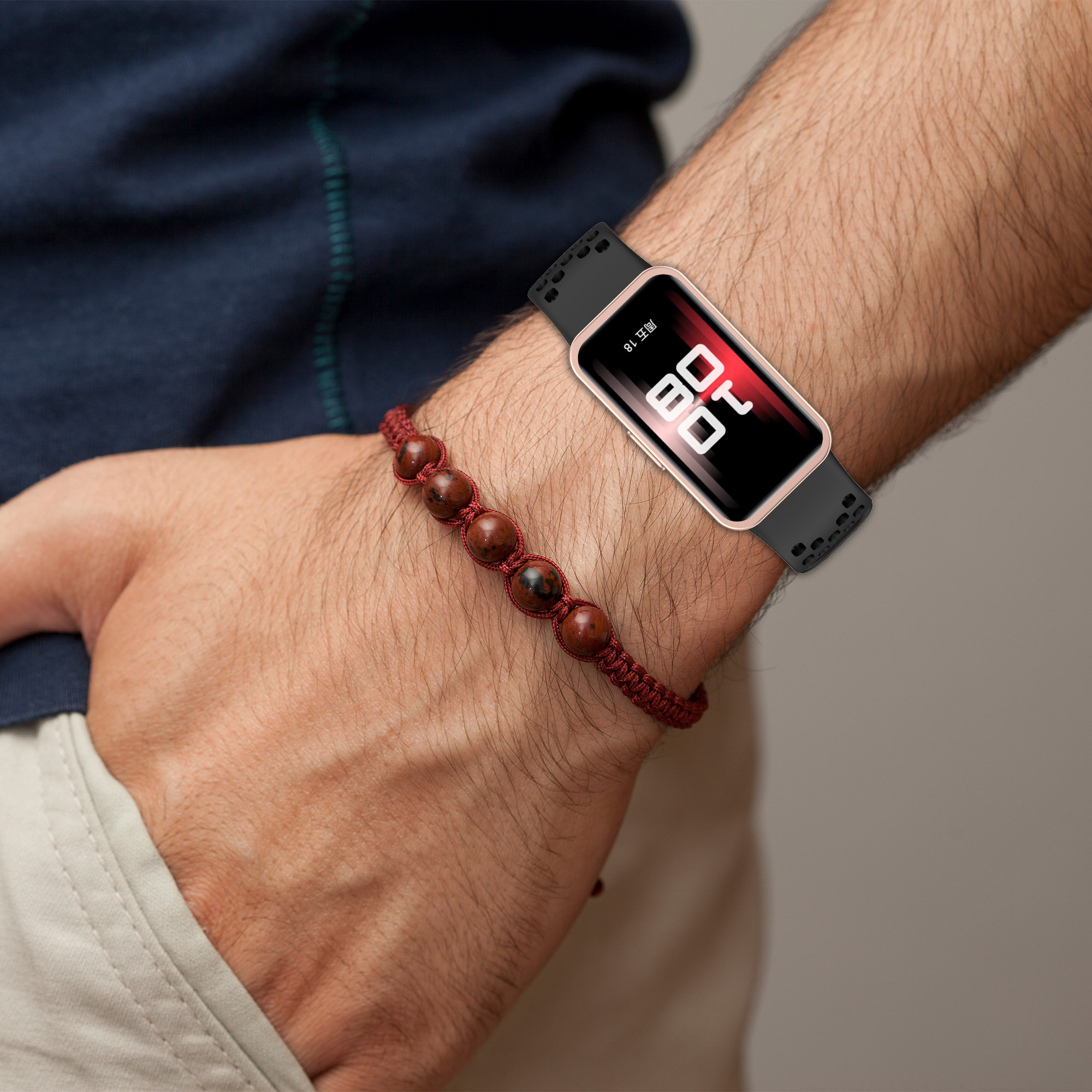 Handgelenk mit Armband und Smartwatch. Die Uhr zeigt Zeit und Datum.
