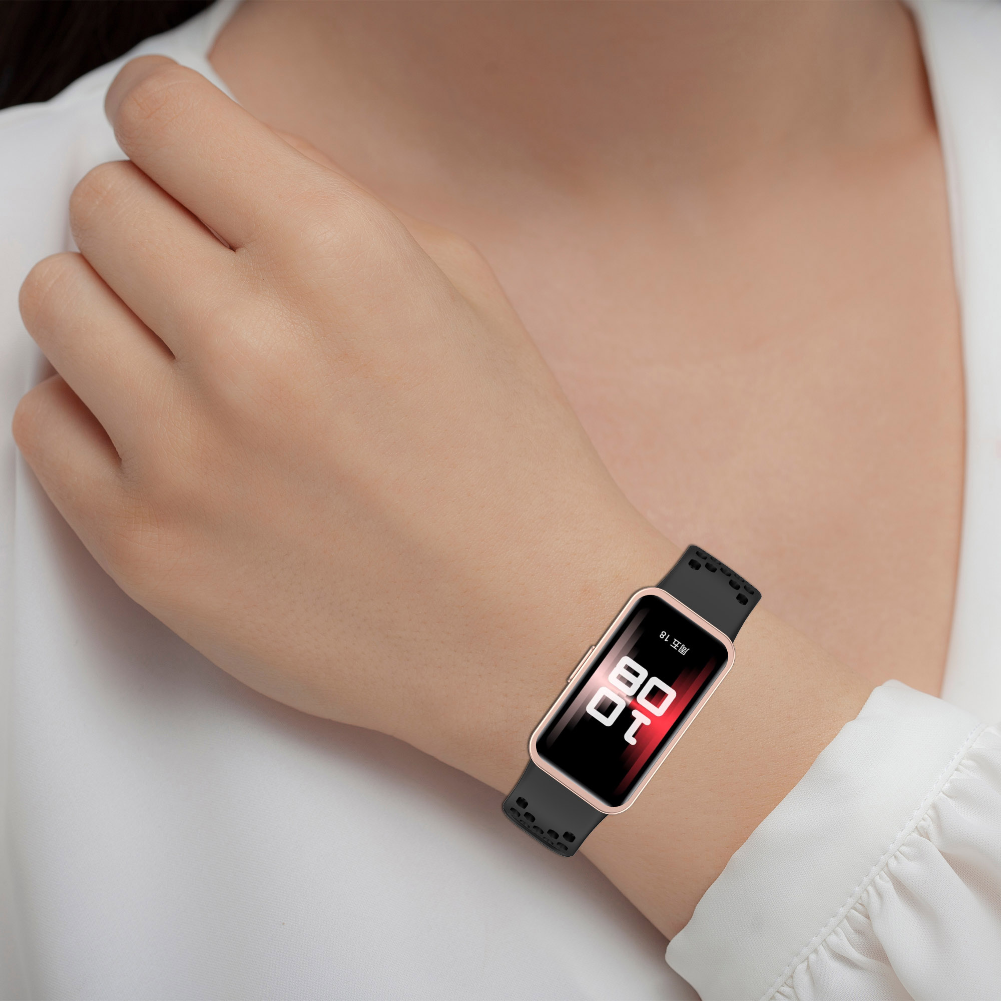 Handgelenk einer Person mit Smartwatch. Schwarzes Band, goldener Rahmen, zeigt die Zeit an.