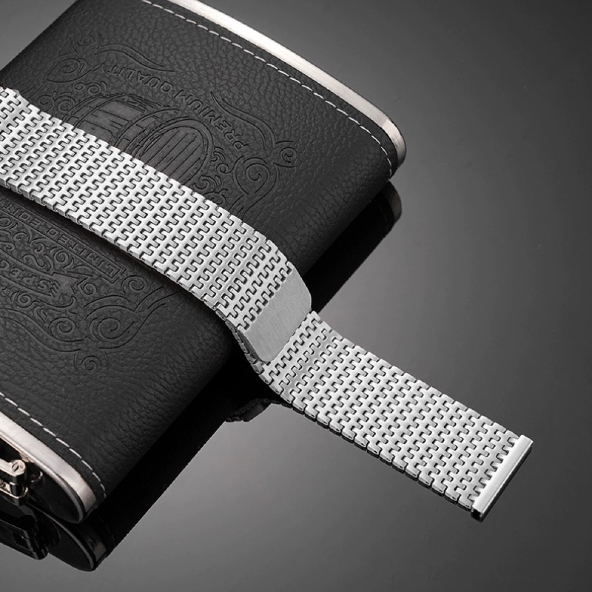 Silbernes Uhrenarmband auf einer Lederflasche, Premium-Qualität, reflektierende Oberfläche.