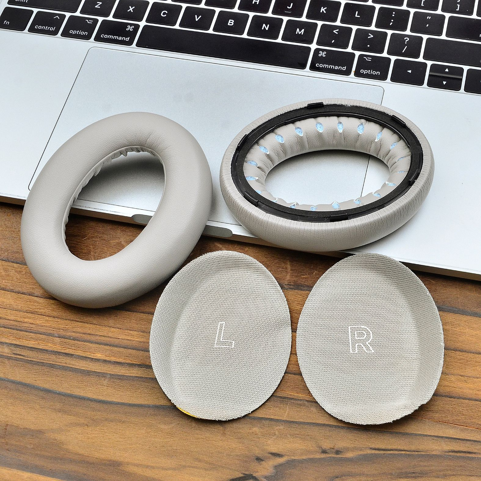 Poduszki i podkładki do słuchawek z otwartym laptopem w tle. Widoczne litery L i R.