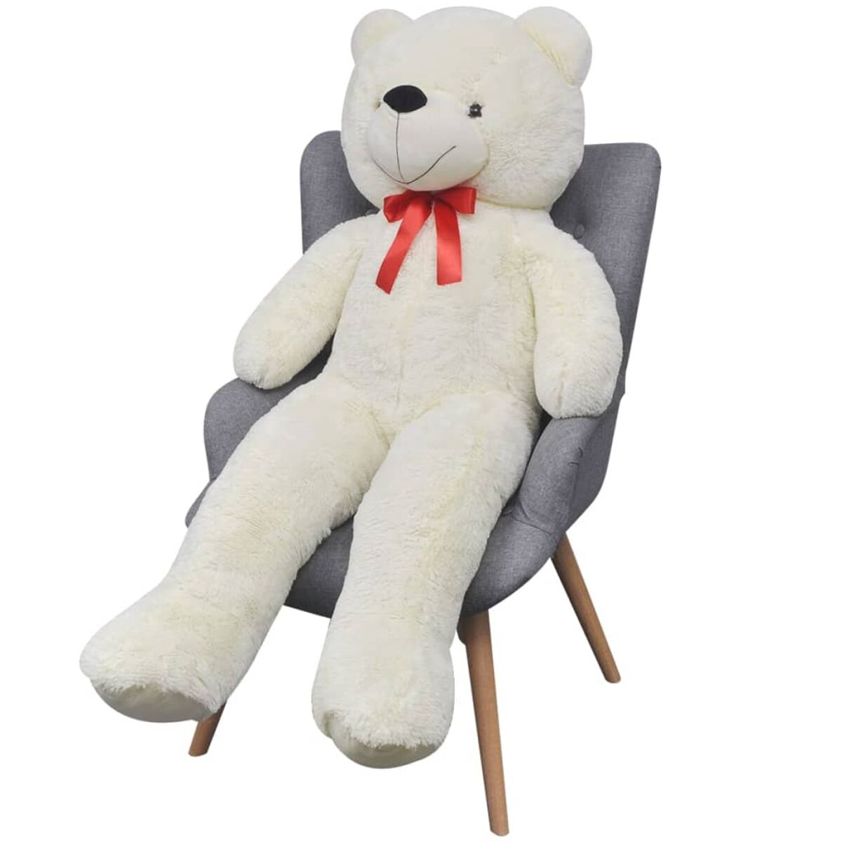 Ein großer, flauschiger weißer Teddybär sitzt auf einem grauen Stuhl mit roter Fliege.