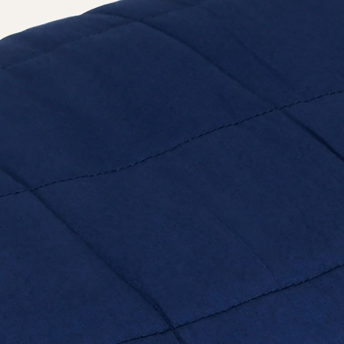 Dunkelblaue Steppdecke mit sichtbaren Nähten.