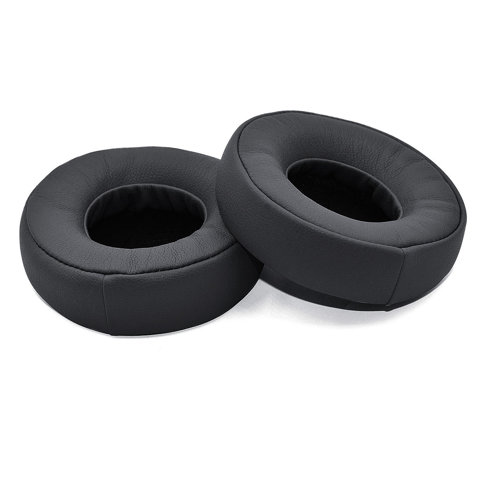 Dwie czarne, okrągłe poduszki na uszy. Mają okrągły kształt i są wykonane z miękkiego materiału.