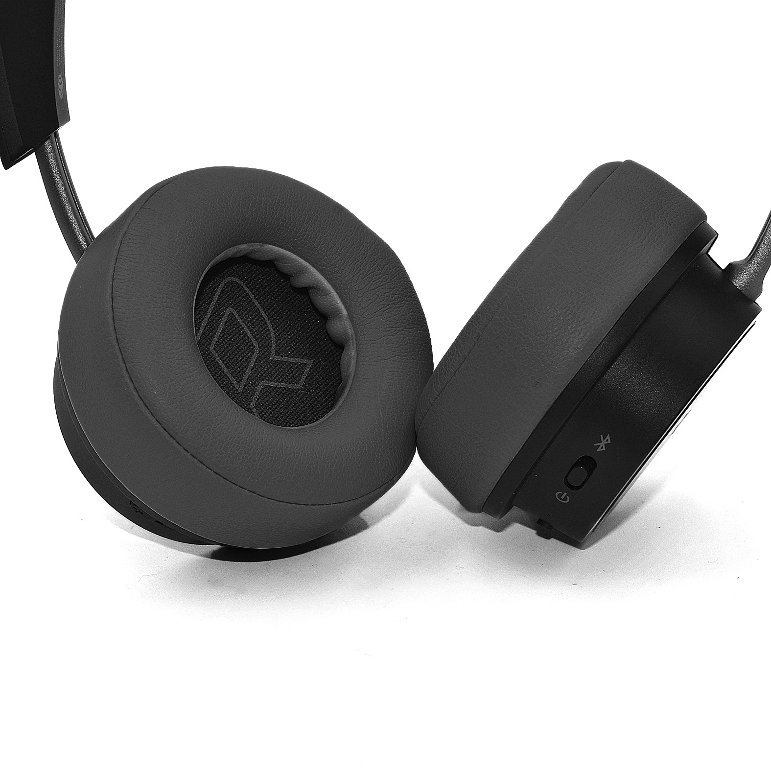 Słuchawki, szare nauszniki i pałąk. Przyciski na prawym nauszniku. Białe tło. Widok z boku.