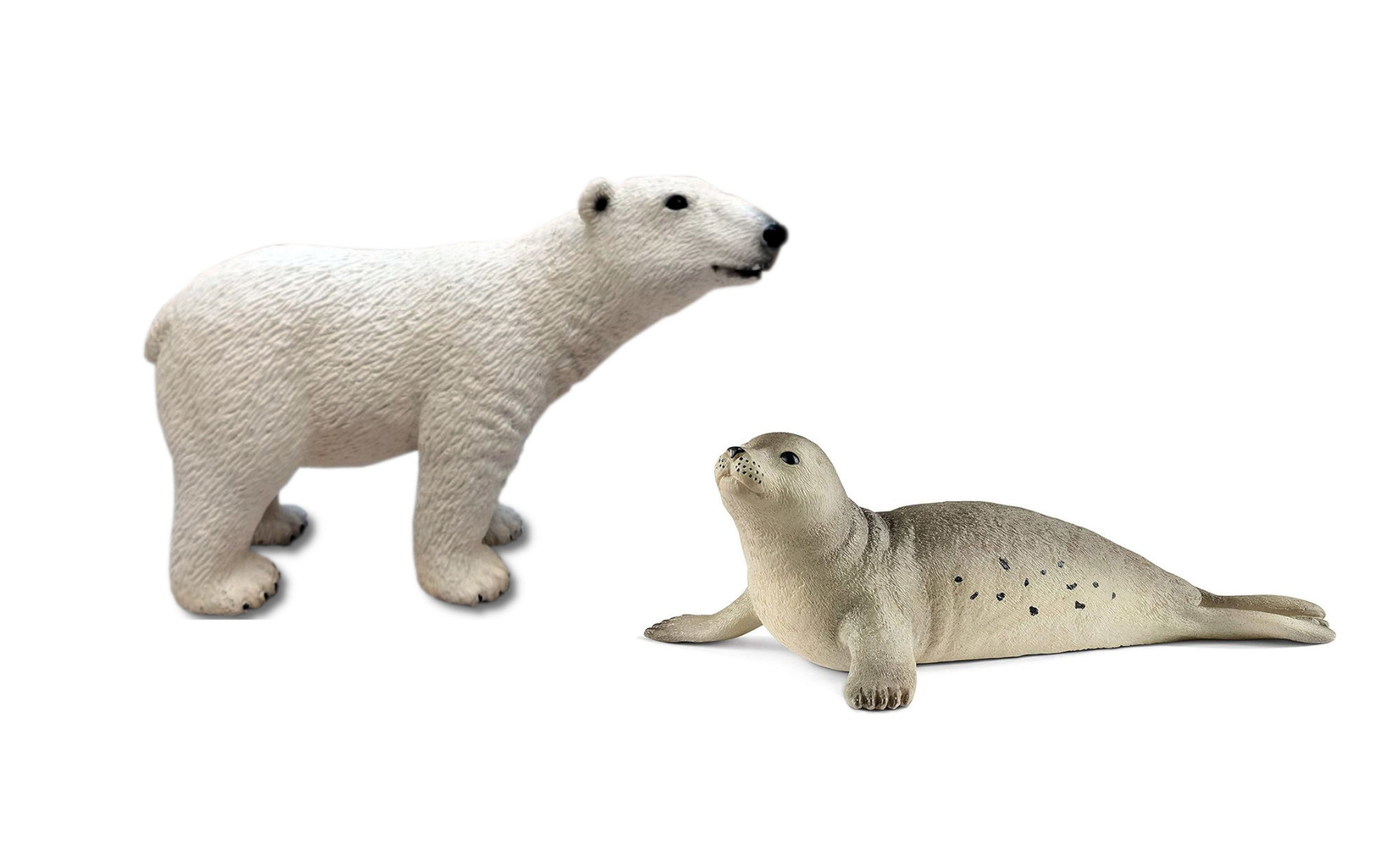 Ein Eisbär und ein Robben-Spielzeug auf weißem Hintergrund.