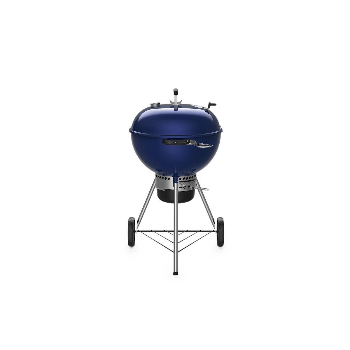Una parrilla Weber redonda de color azul oscuro sobre un fondo blanco. Tiene un soporte plateado y ruedas.