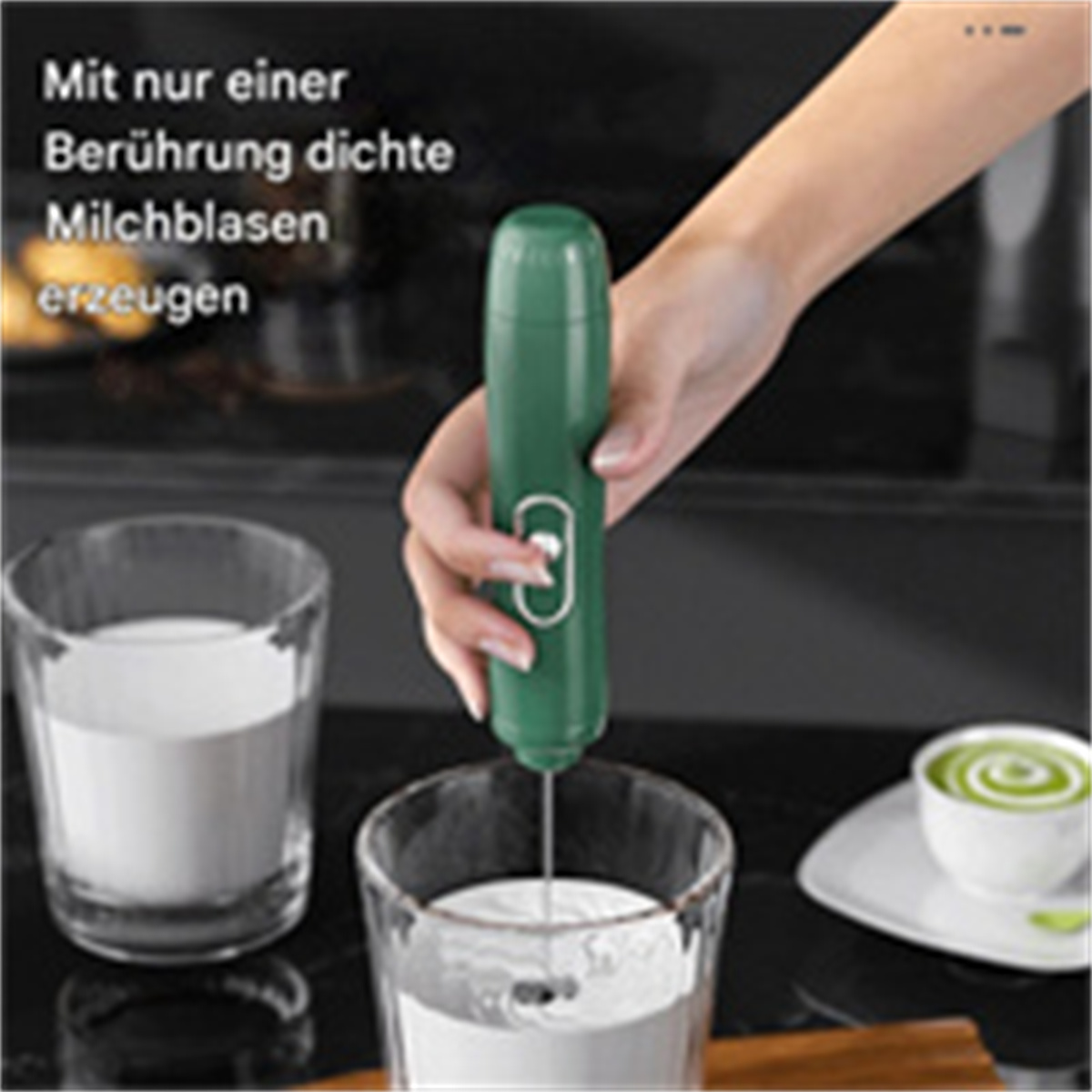 Eine Hand hält einen grünen Milchaufschäumer mit zwei Gläsern Milch.