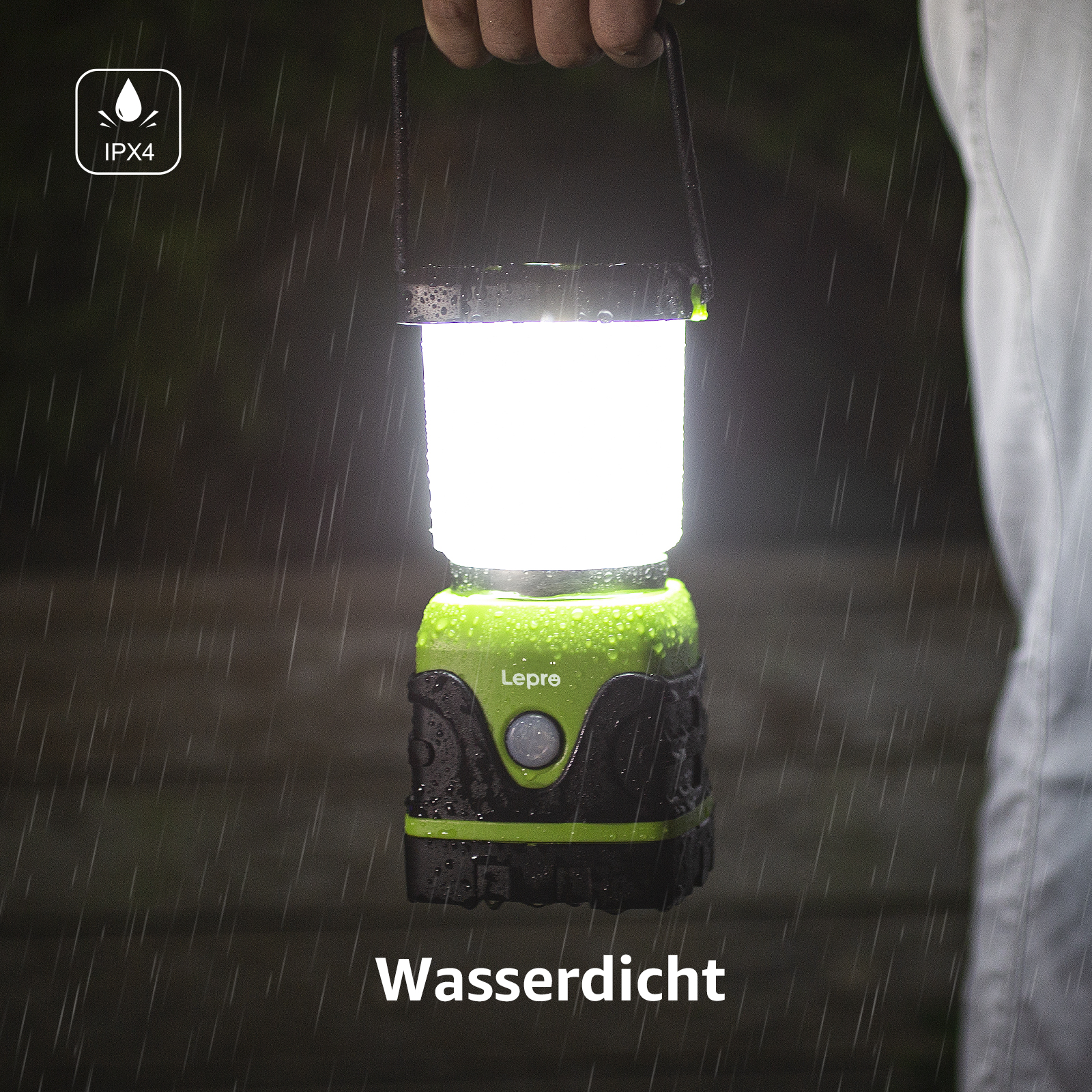Eine hellgrüne und schwarze wasserdichte Laterne leuchtet im Regen. Hand hält sie.