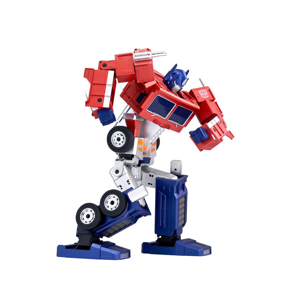 Un robot de juguete Optimus Prime rojo y azul en pose de transformación, aislado sobre fondo blanco.