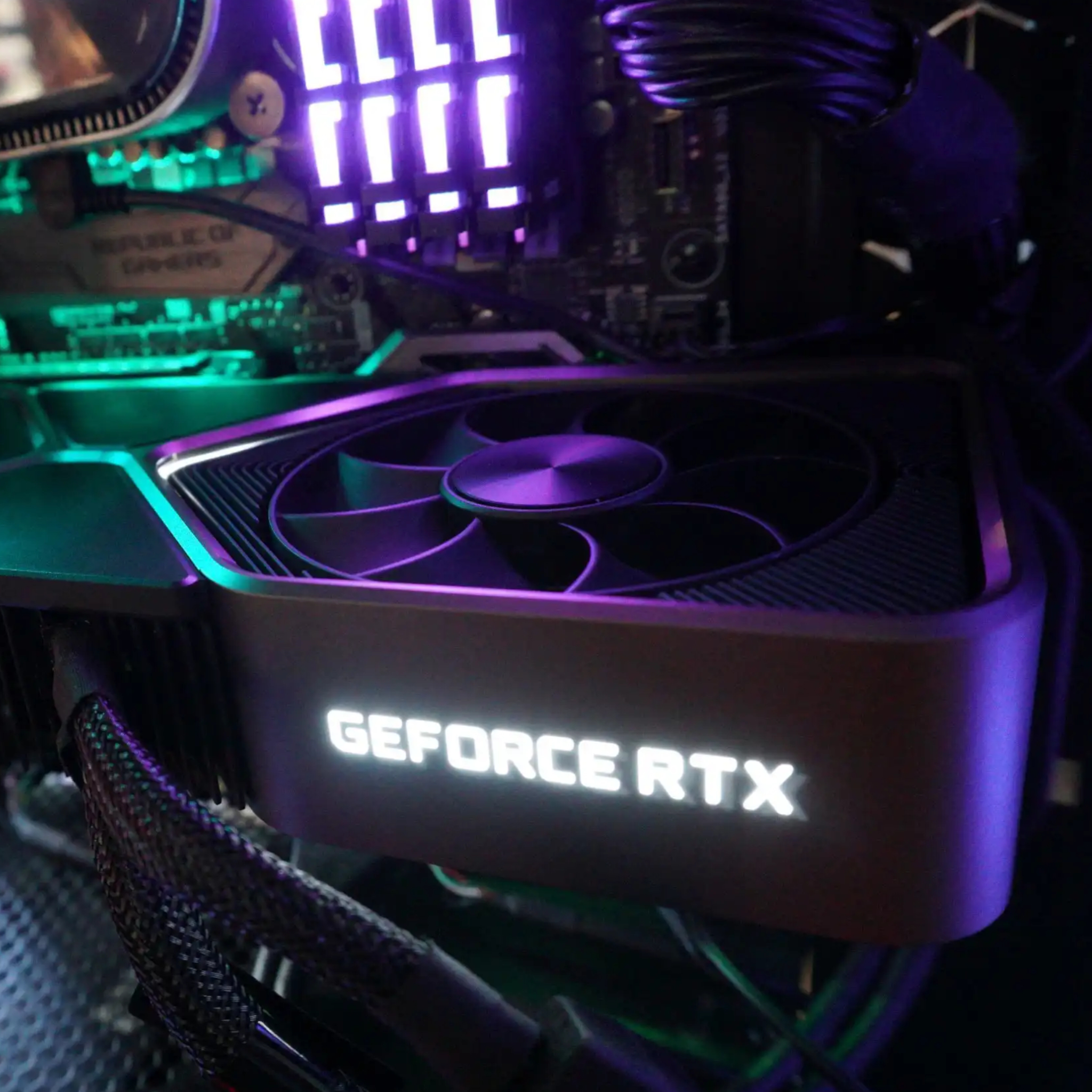 Primer plano de una tarjeta gráfica dentro de una computadora. La tarjeta tiene la leyenda 'GEFORCE RTX'.